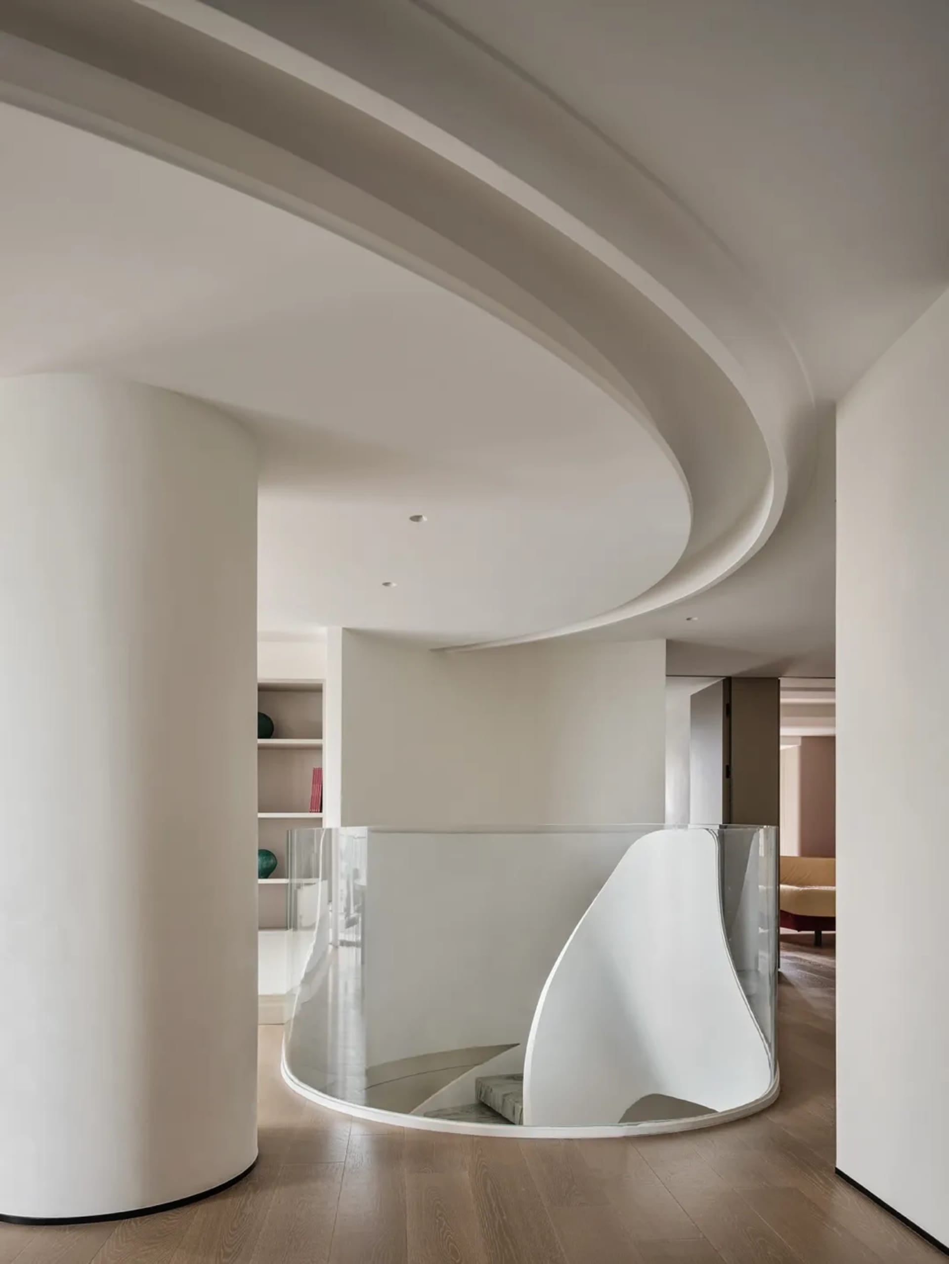 Modern living room interior featuring a sleek, glass-enclosed staircase