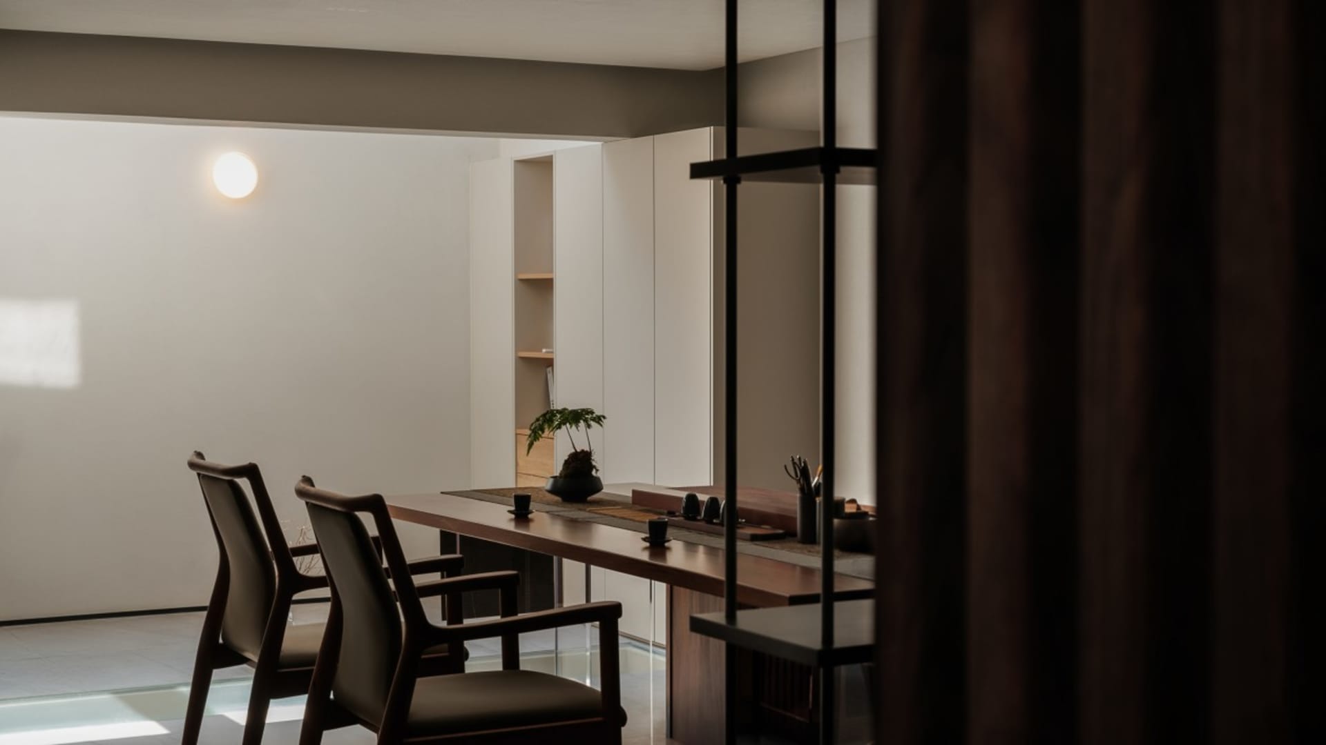 A modern minimalist living room featuring wood furniture and a clean, open floor plan.