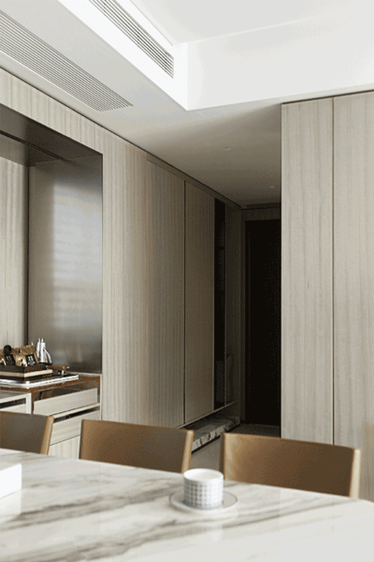 Modern kitchen and dining area with marble countertops and wooden cabinets.