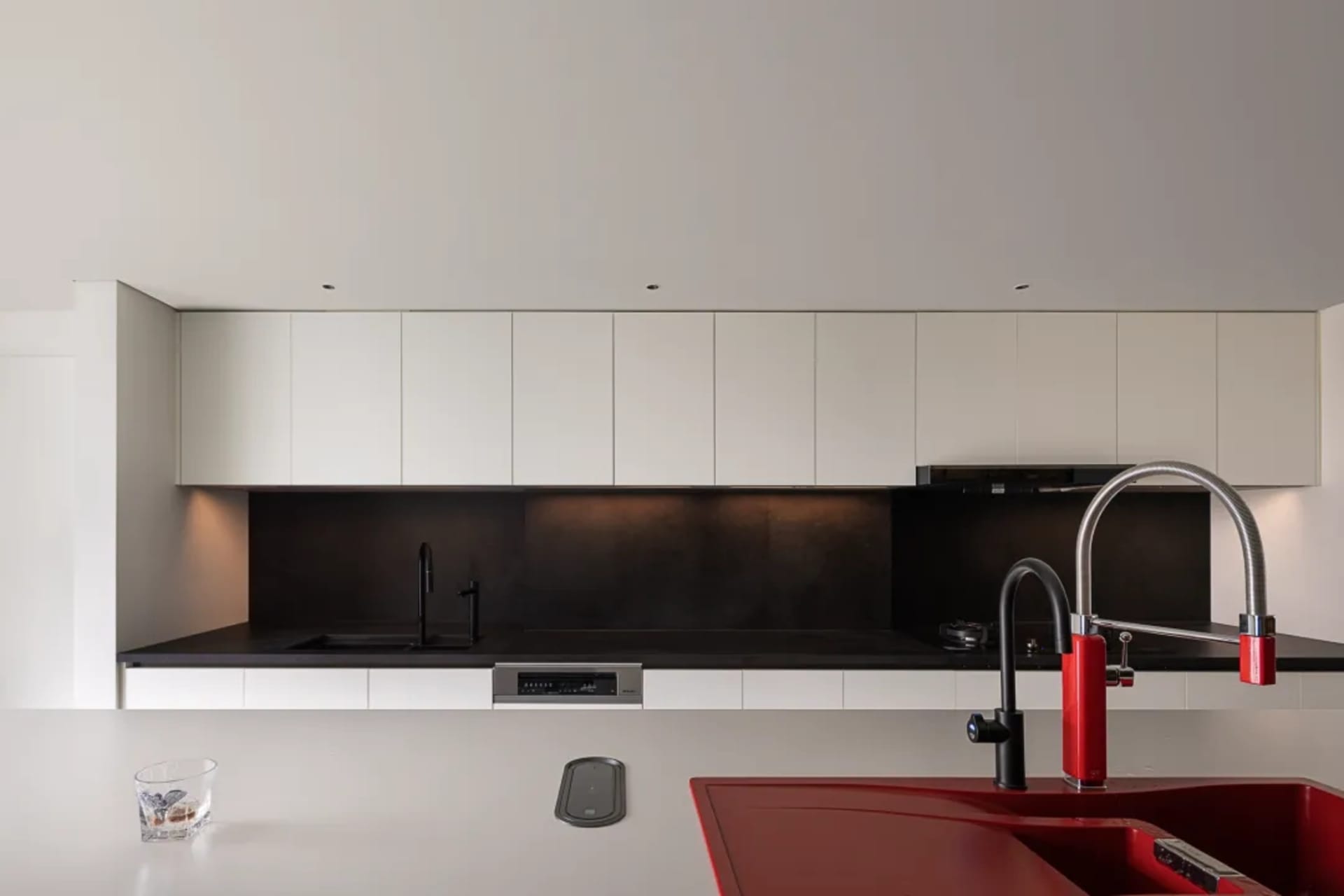 A modern kitchen featuring a black countertop and sleek stainless steel appliances.