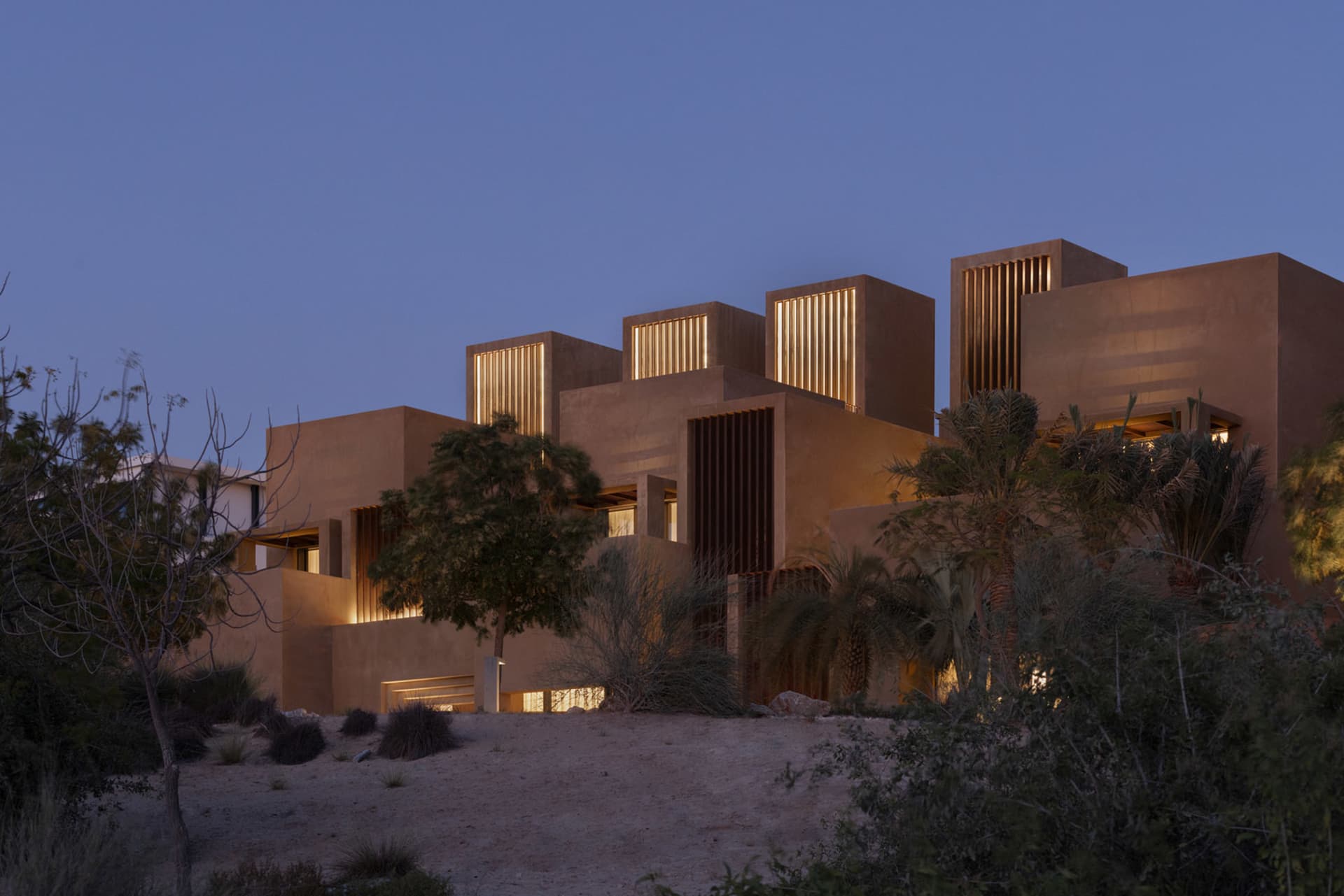 Modern building featuring concrete and glass materials under twilight sky.