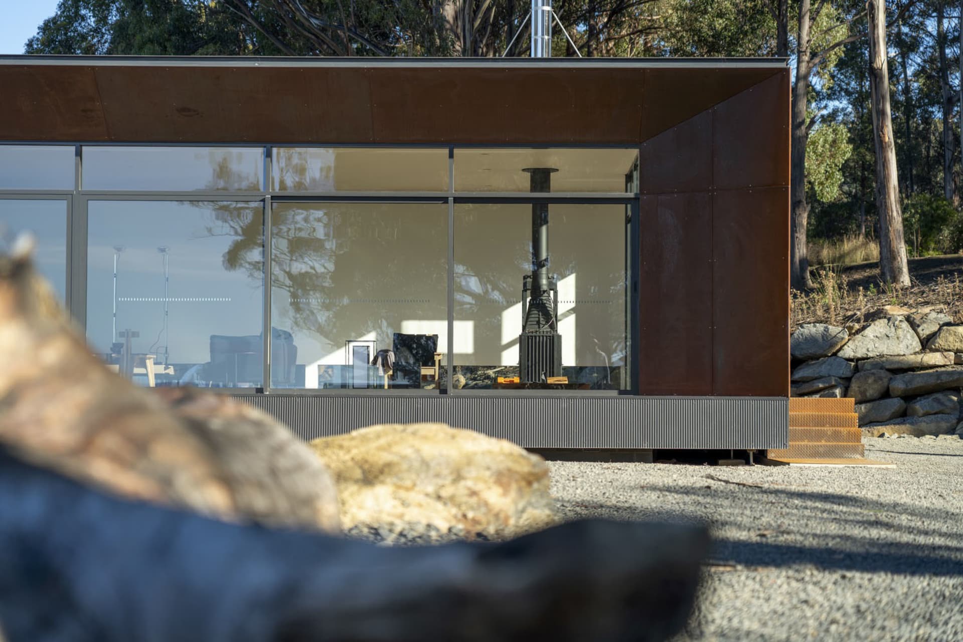 Modern residential house featuring metal, glass, and stone materials.