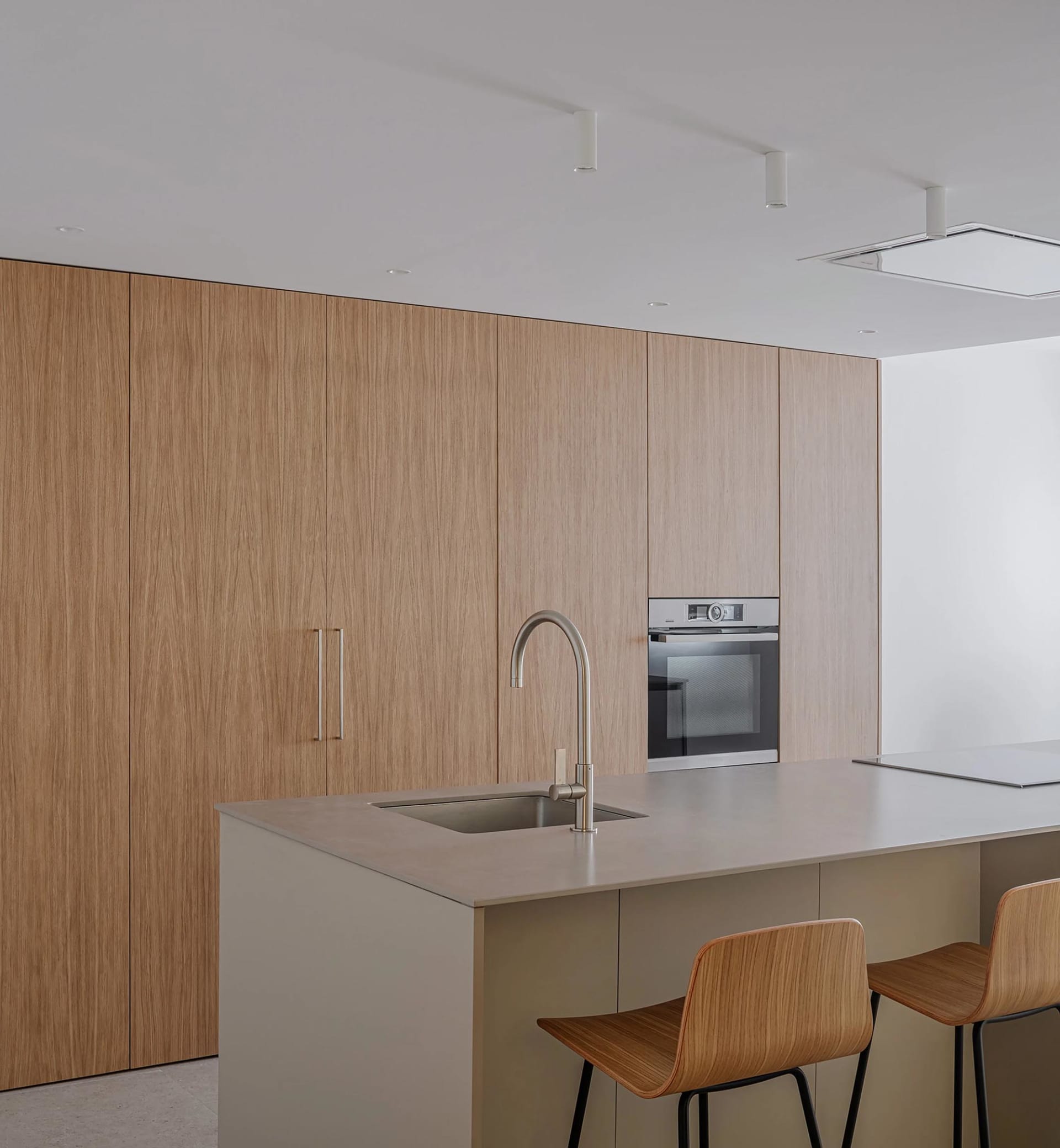 Modern minimalist kitchen with wooden cabinets and stainless steel appliances.