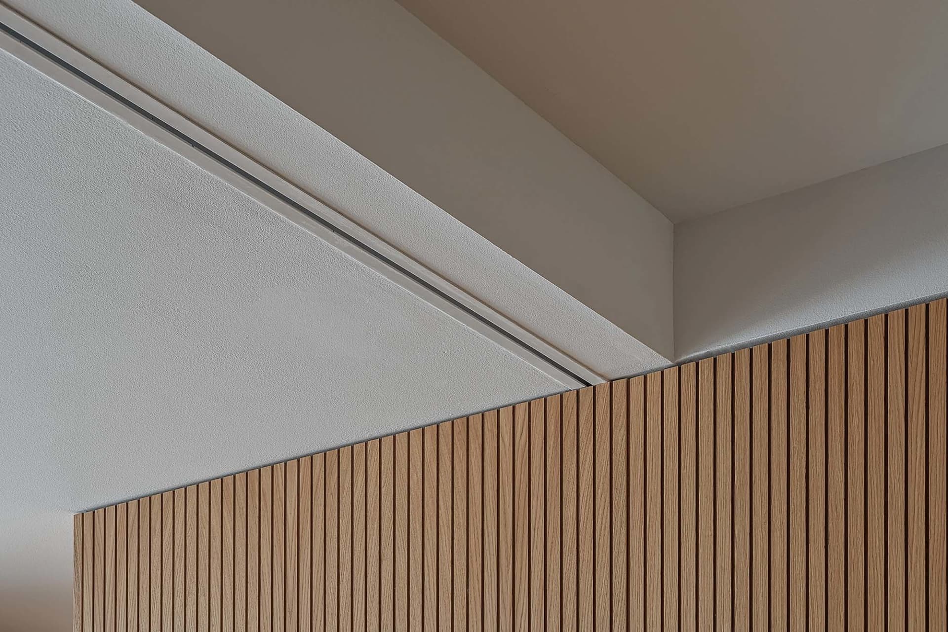 A modern interior design featuring a wall covered in wooden slats.