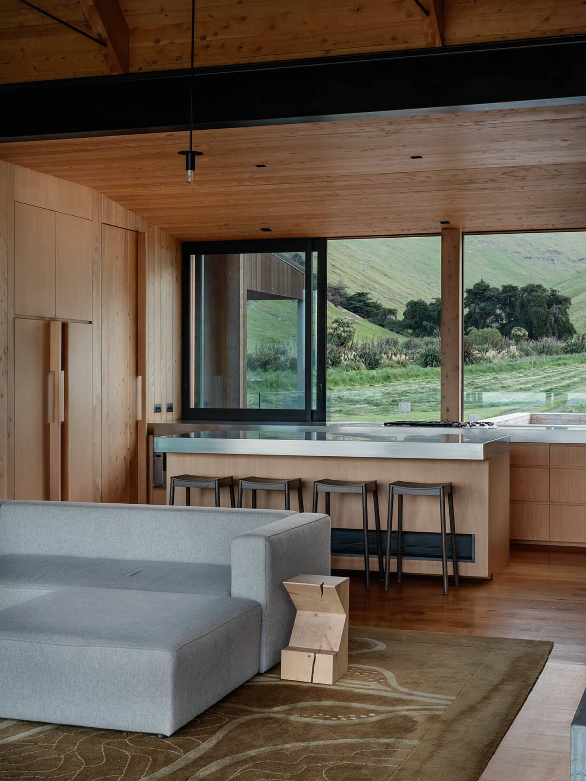 A modern interior design with wooden elements and a view of greenery outside.