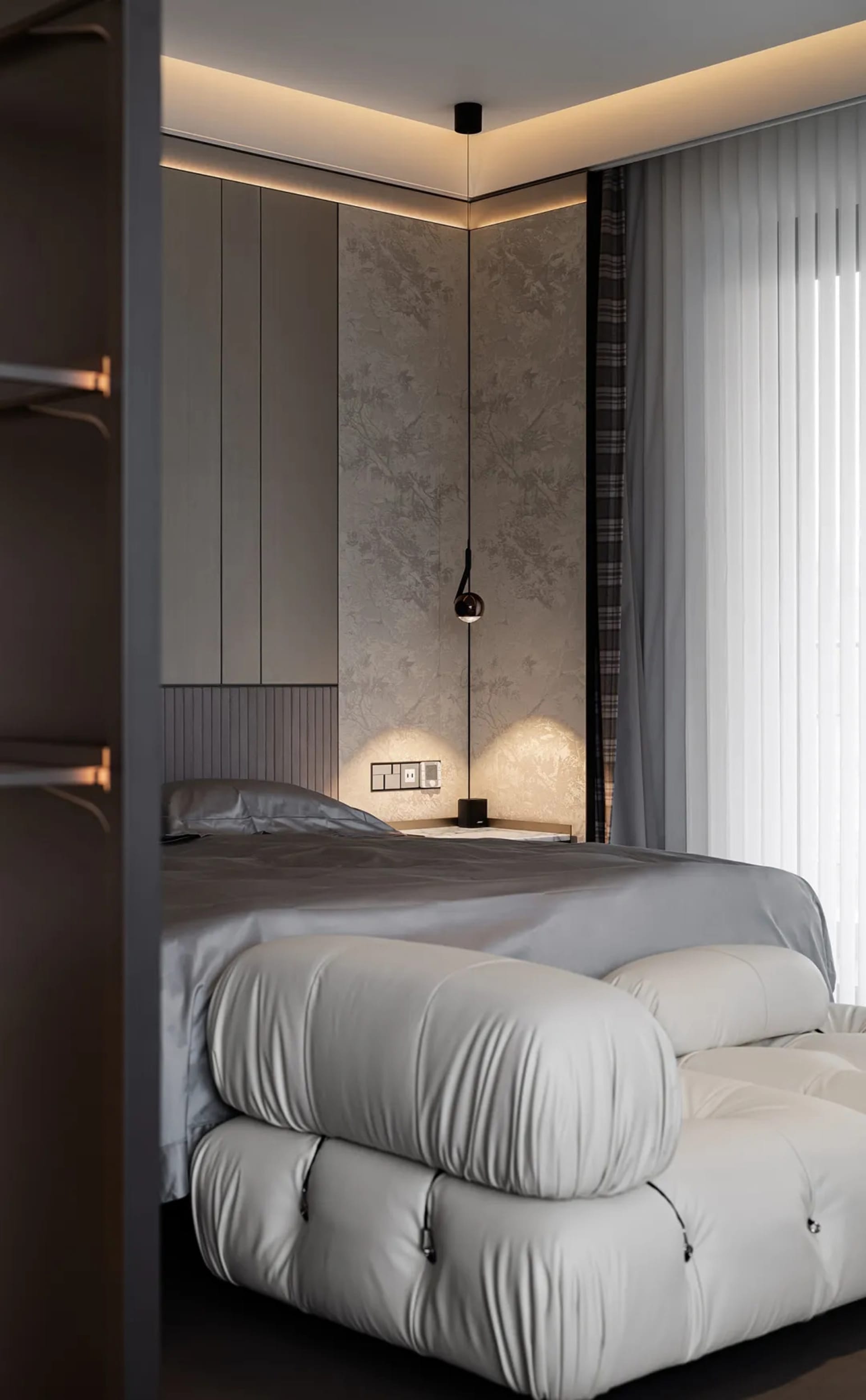 A minimalist bedroom with a white bed frame and light grey bedding, featuring a modern light fixture and a sleek, grey wardro