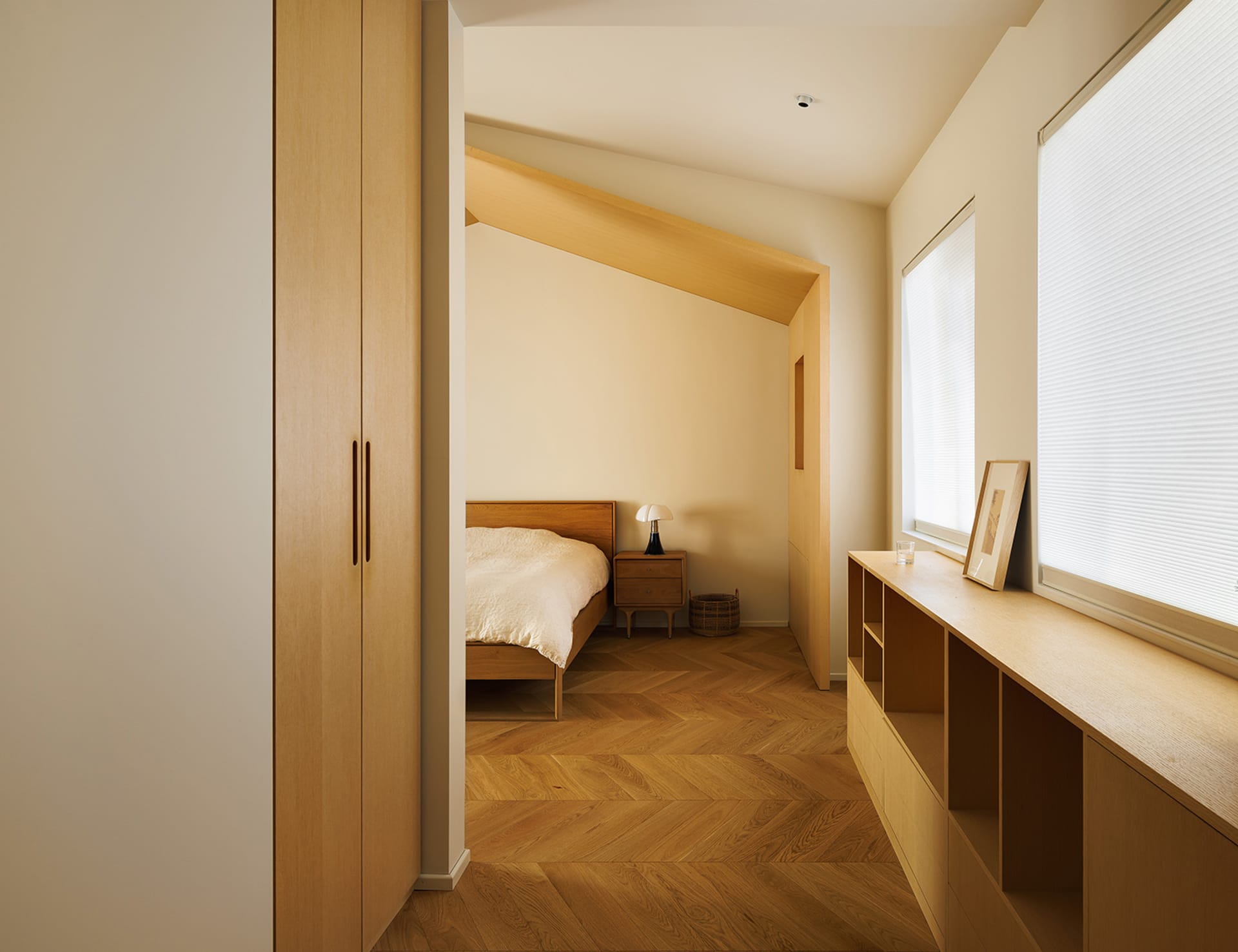 A minimalist bedroom with wooden furniture and a window