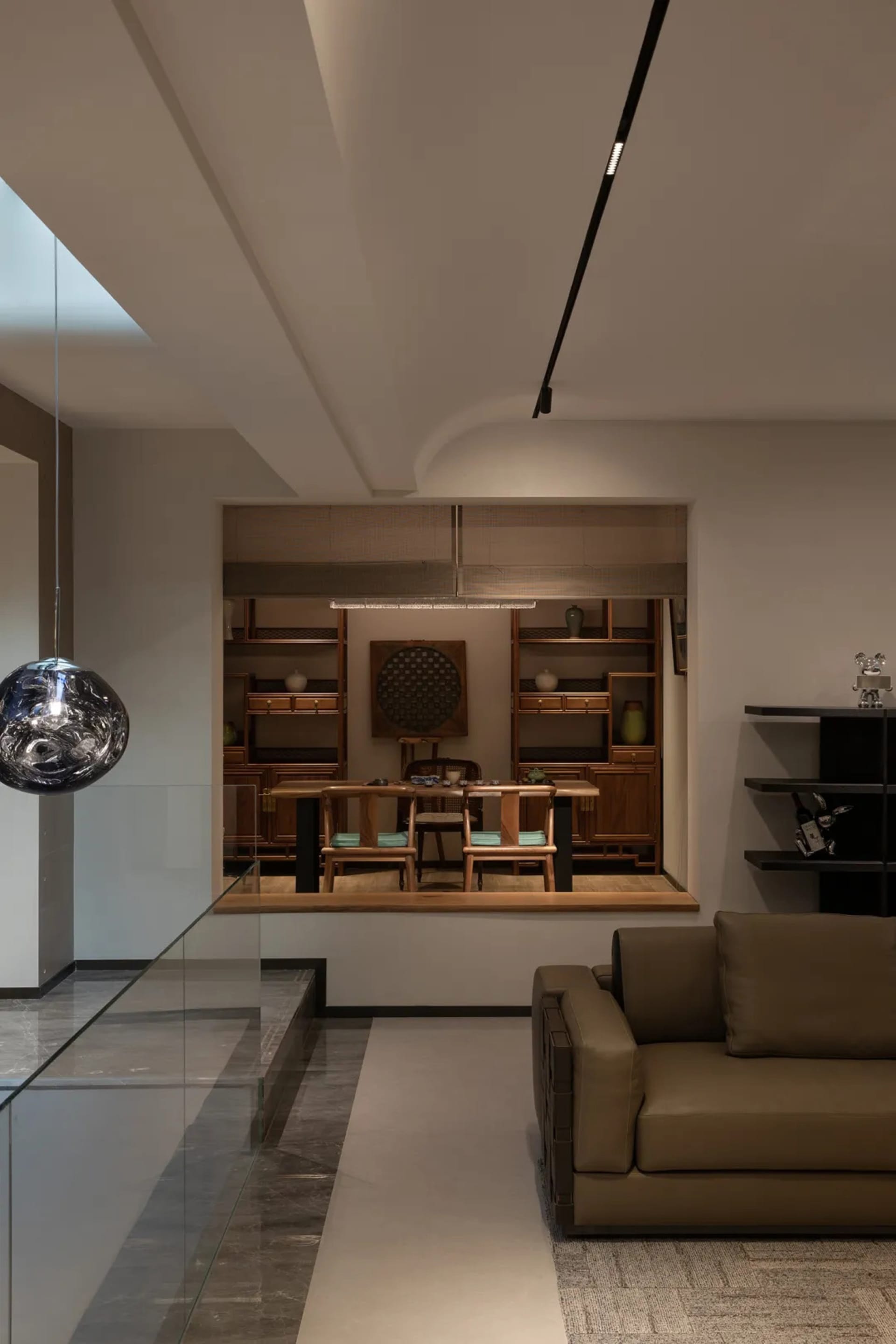 Modern minimalist living room featuring wooden furniture, leather accents, and glass elements.