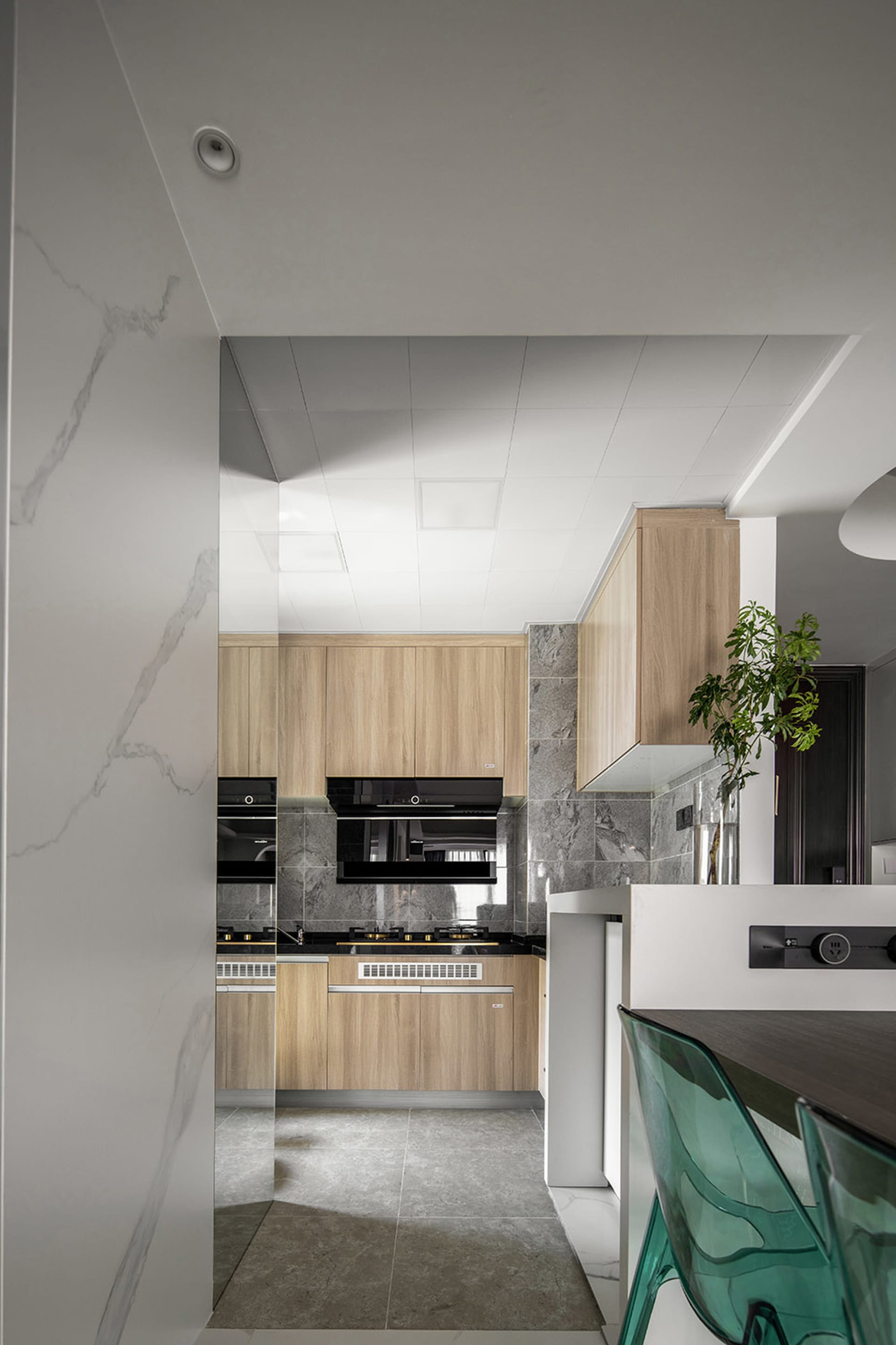 Modern kitchen interior with wooden cabinets and marble countertops.
