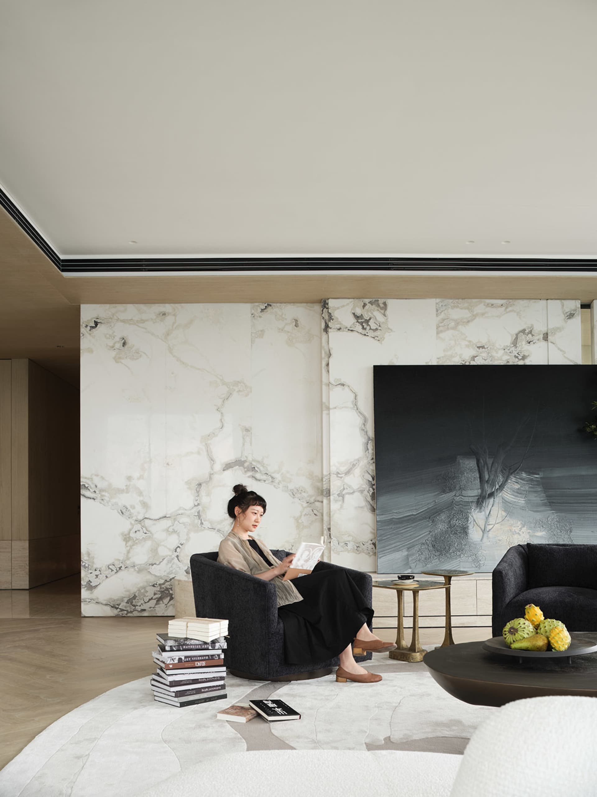 A minimalist living room with a marble accent wall and modern furniture.
