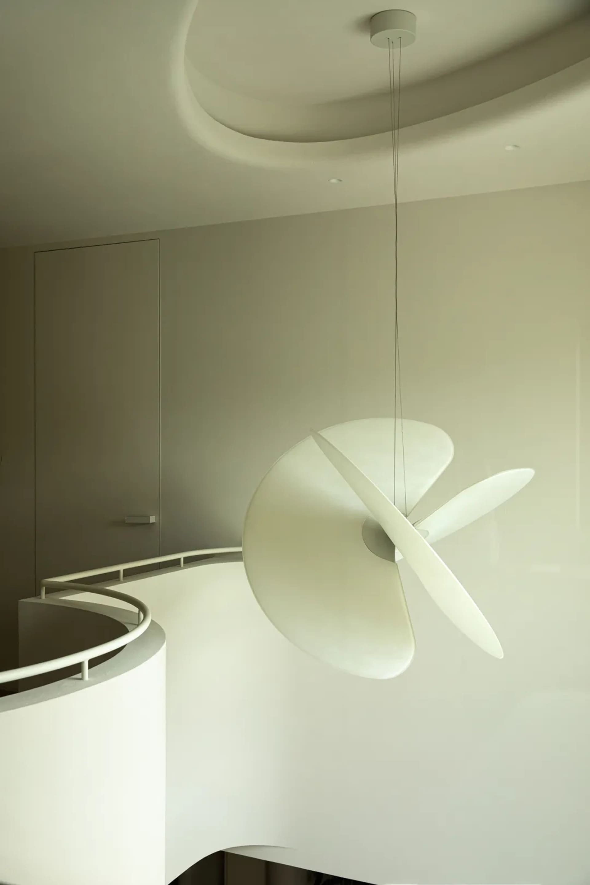 A modern hanging light fixture with a metallic and glass design