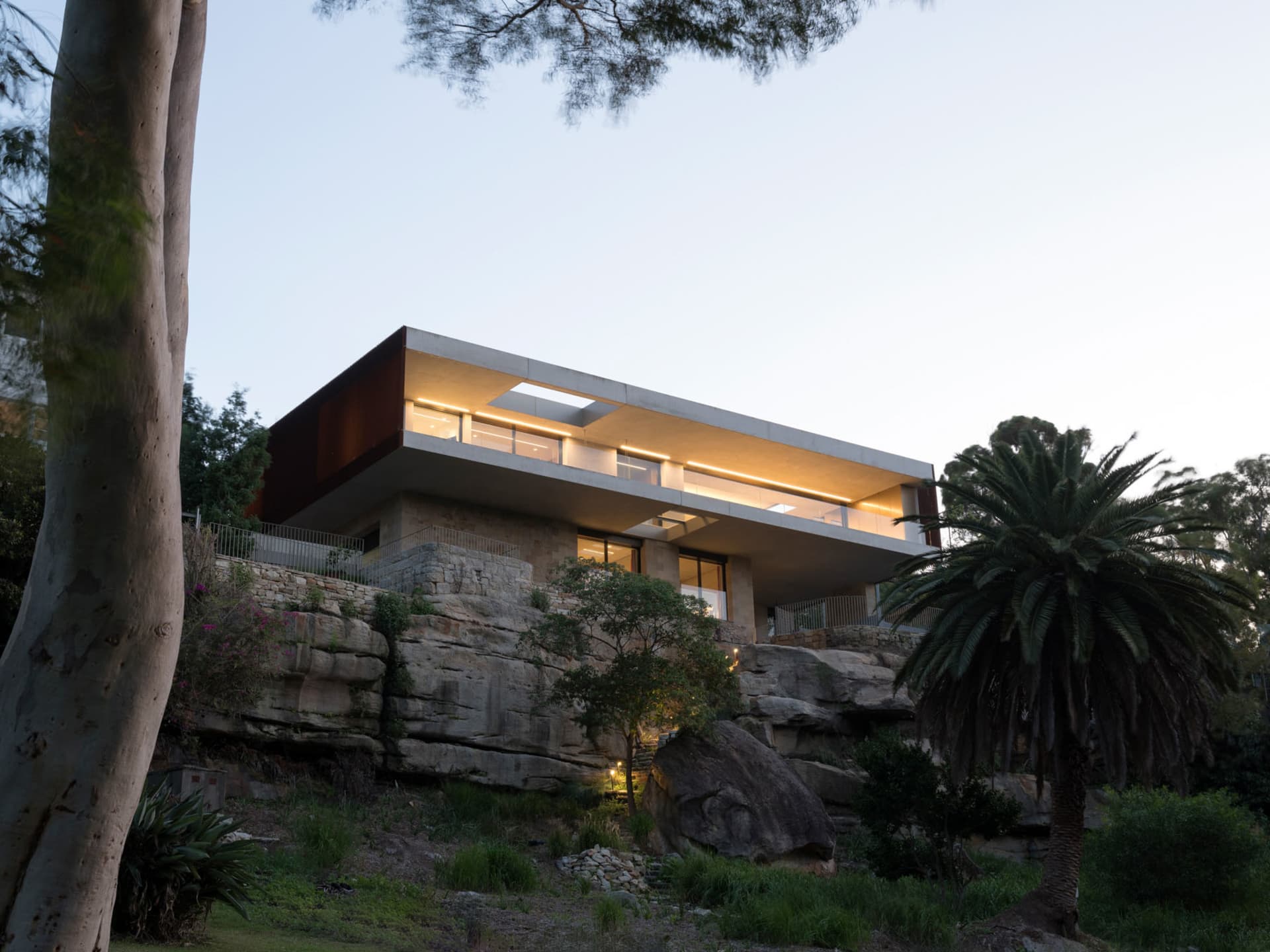A modern residential home featuring stone, concrete, and glass materials.