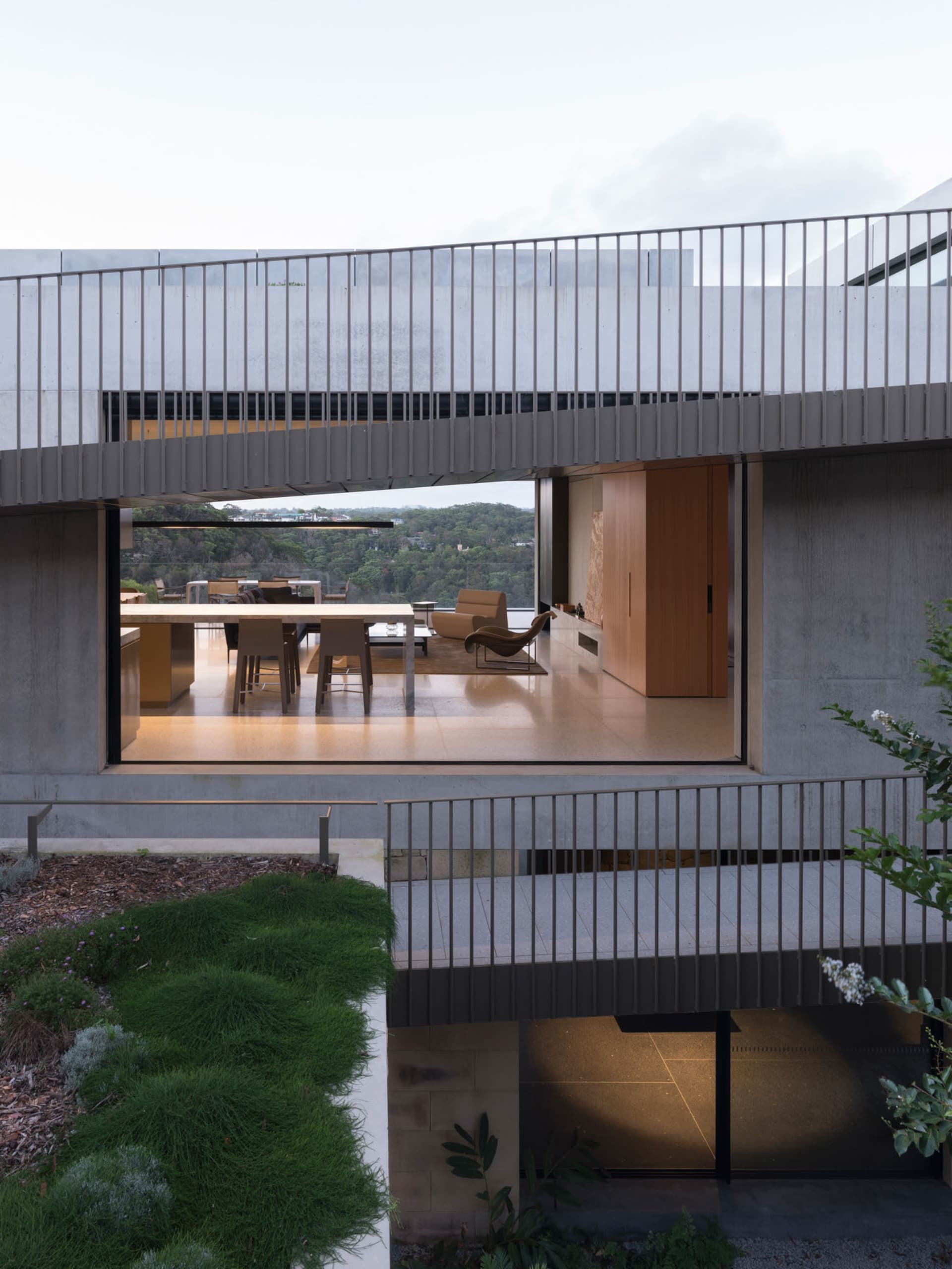 A modern residential interior with concrete walls and glass elements.