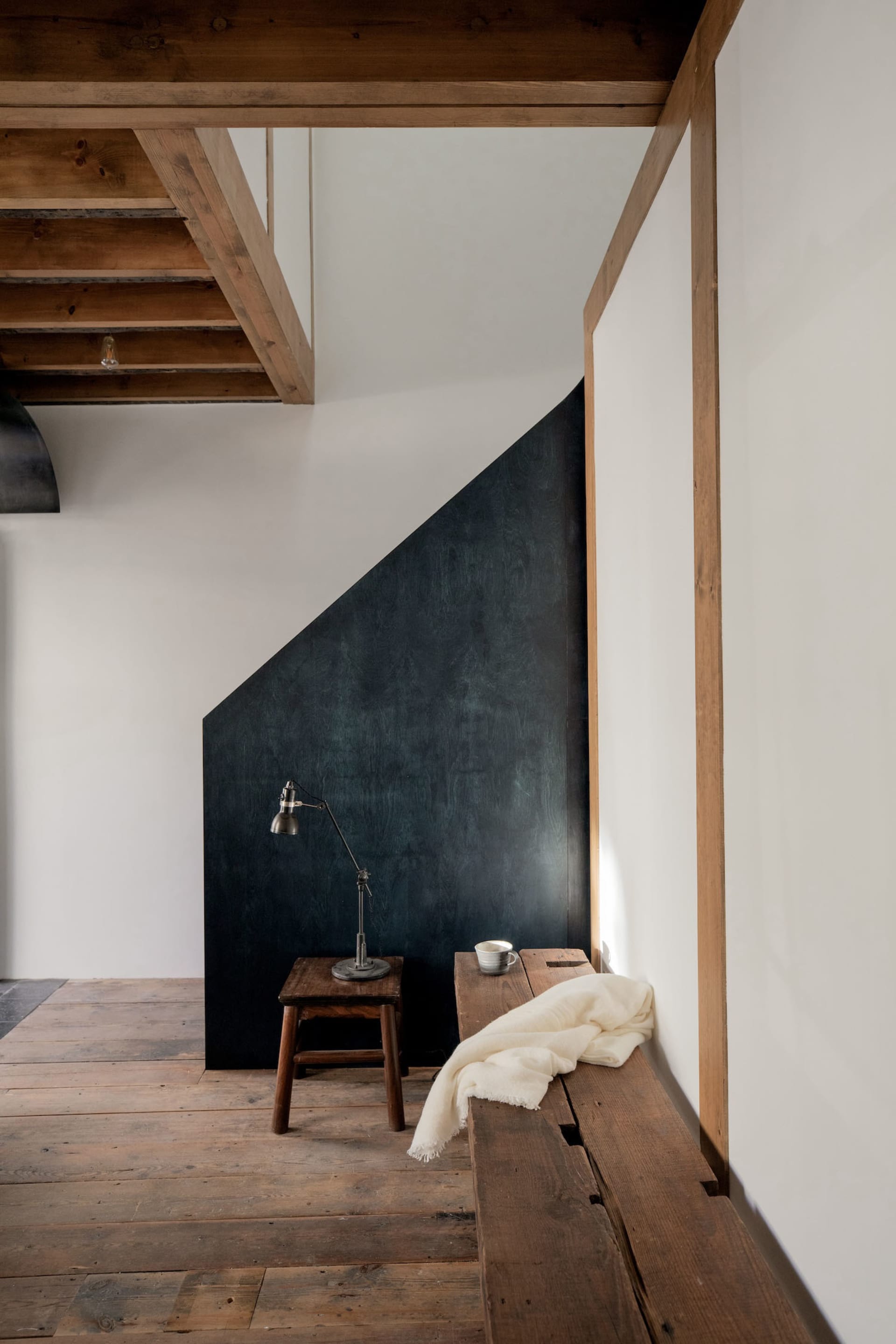 A minimalist interior with a wooden floor and light-colored furnishings.