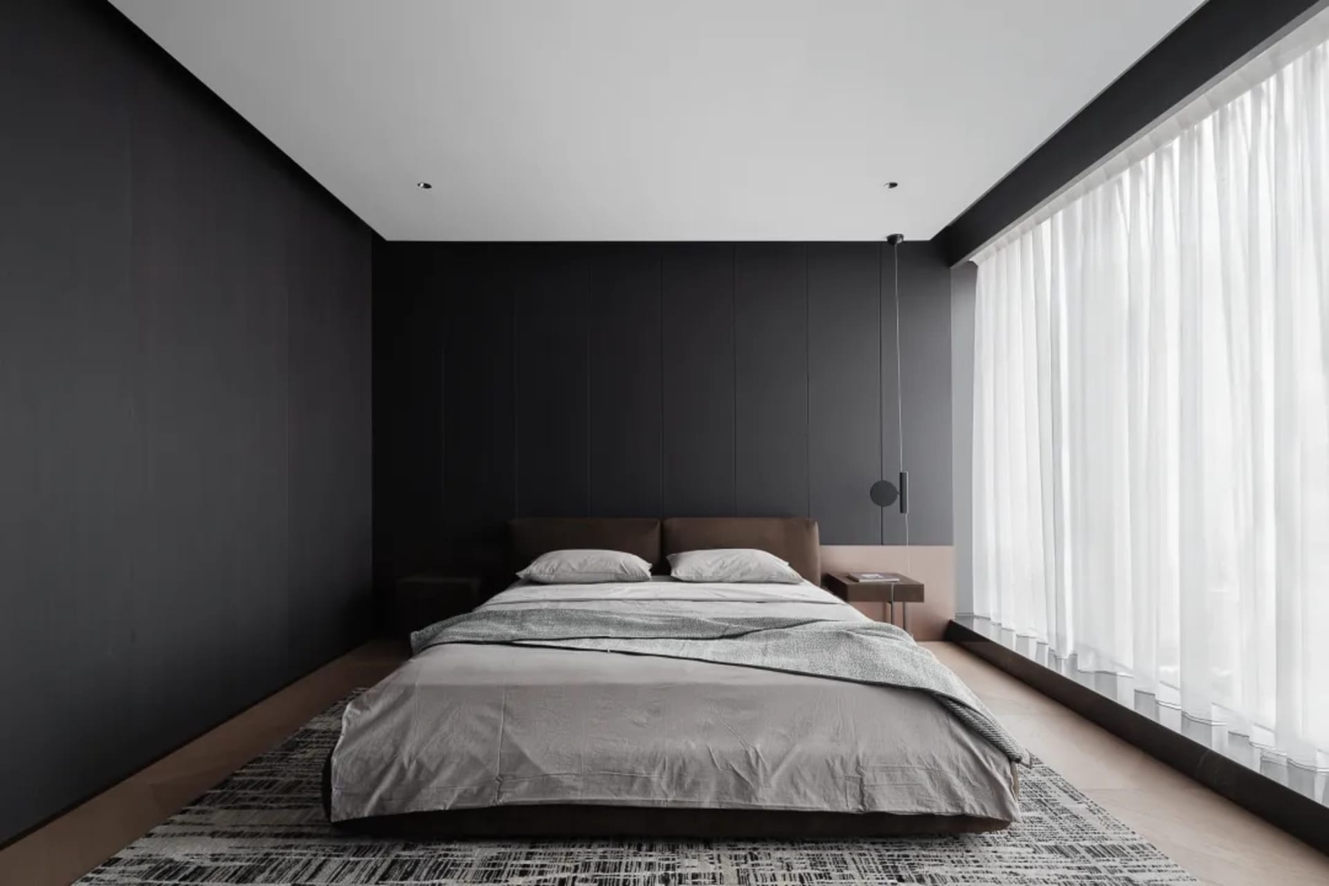 Minimalist bedroom featuring textured wallpaper, modern furniture, and soft lighting.