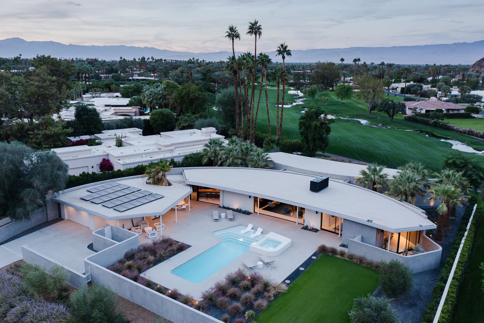 Modern residential exterior featuring concrete, glass, and metal materials.