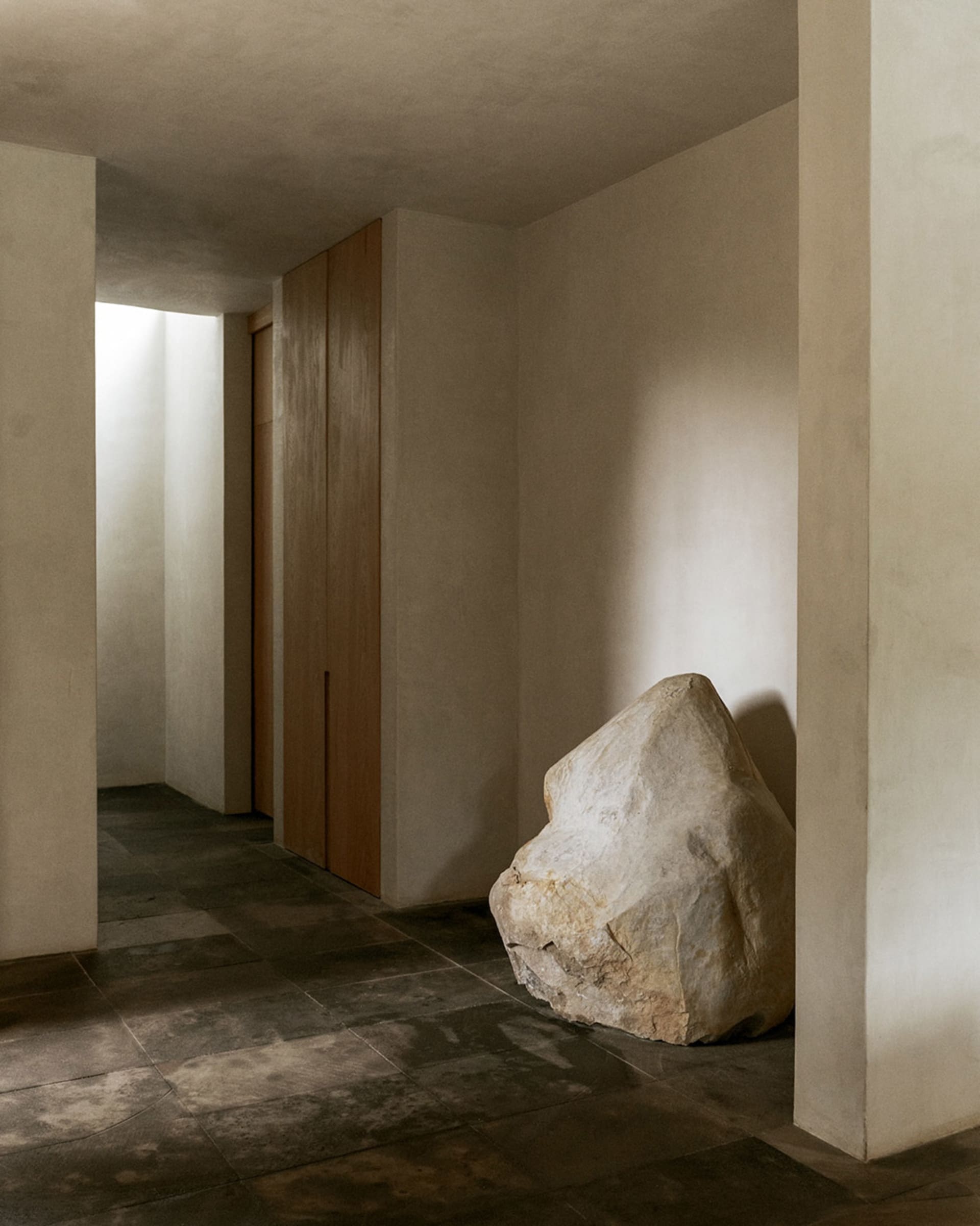A minimalist living room with concrete flooring and modern design elements.