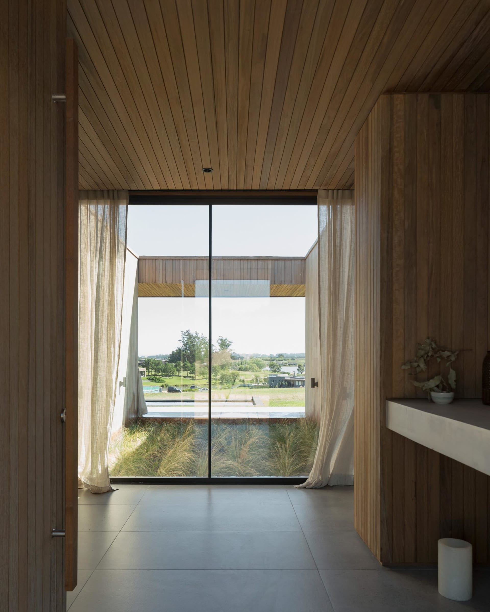 Modern interior design featuring wooden walls, glass windows, and a view of the outdoors.