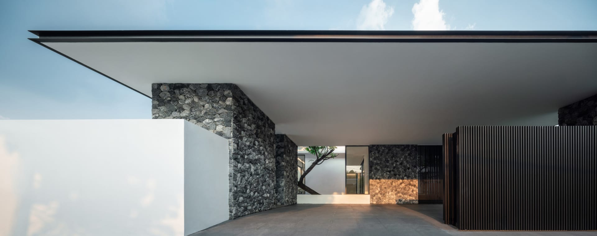 Modern house with a concrete wall and large overhanging roof