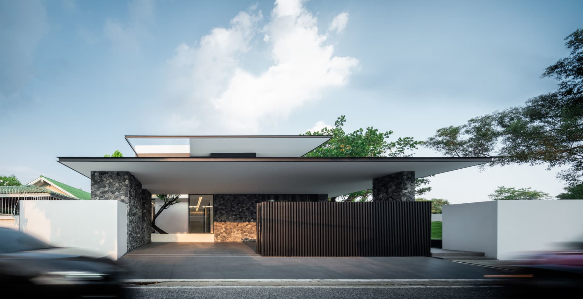 Contemporary residential home with concrete, glass, and stone exterior.