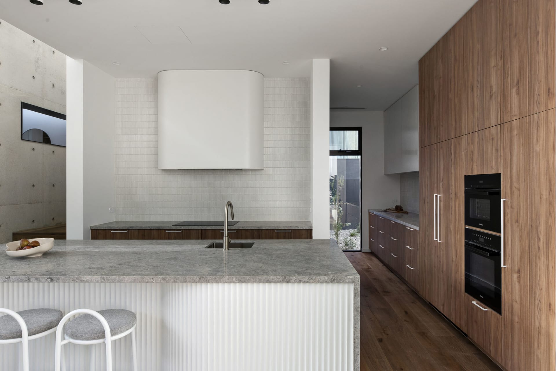Modern minimalist kitchen featuring wood and concrete finishes with a sleek, contemporary design.