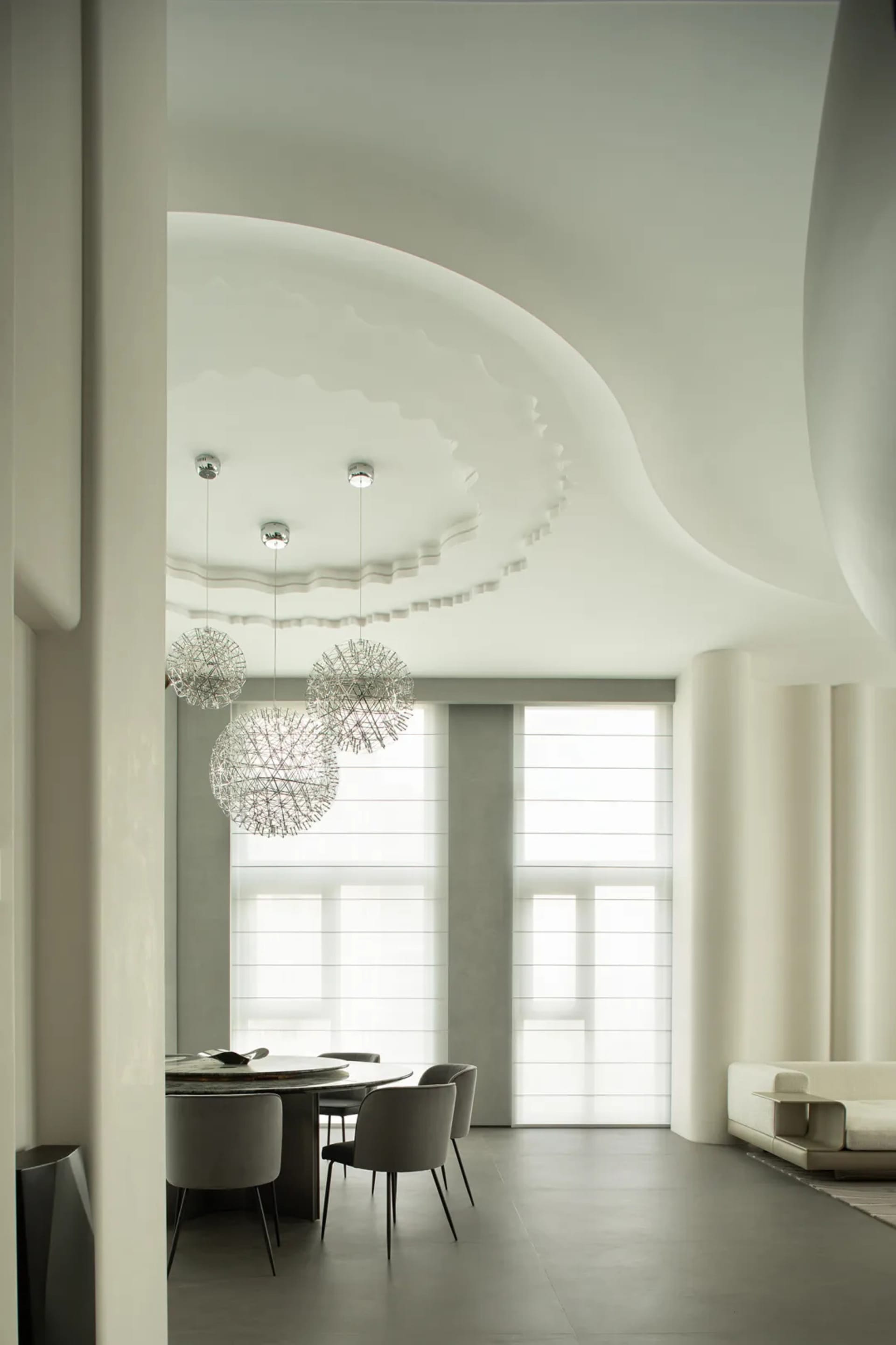 A minimalist dining room featuring textured concrete walls and ceiling.