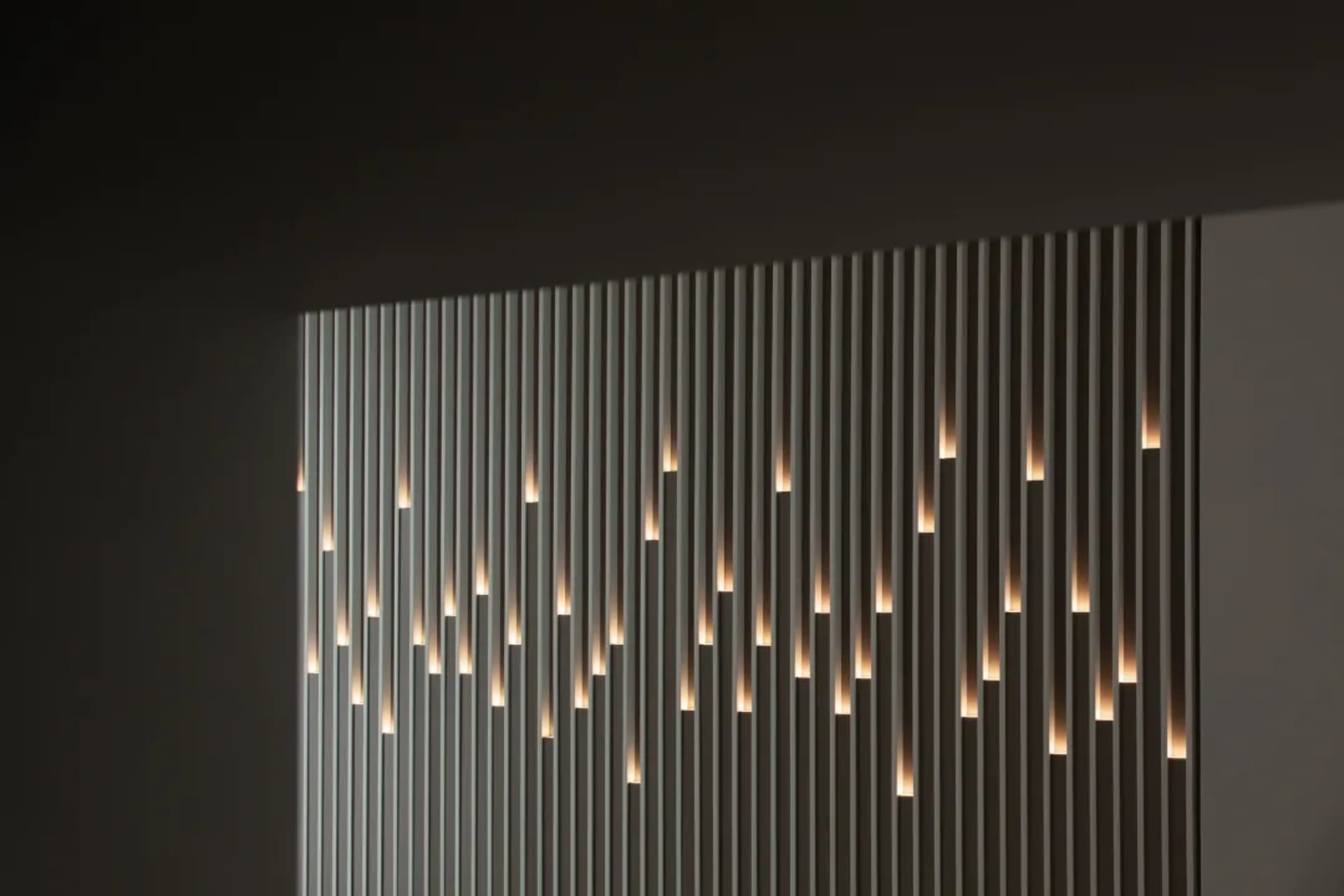 Modern interior wall featuring vertical metal strips with embedded lights.