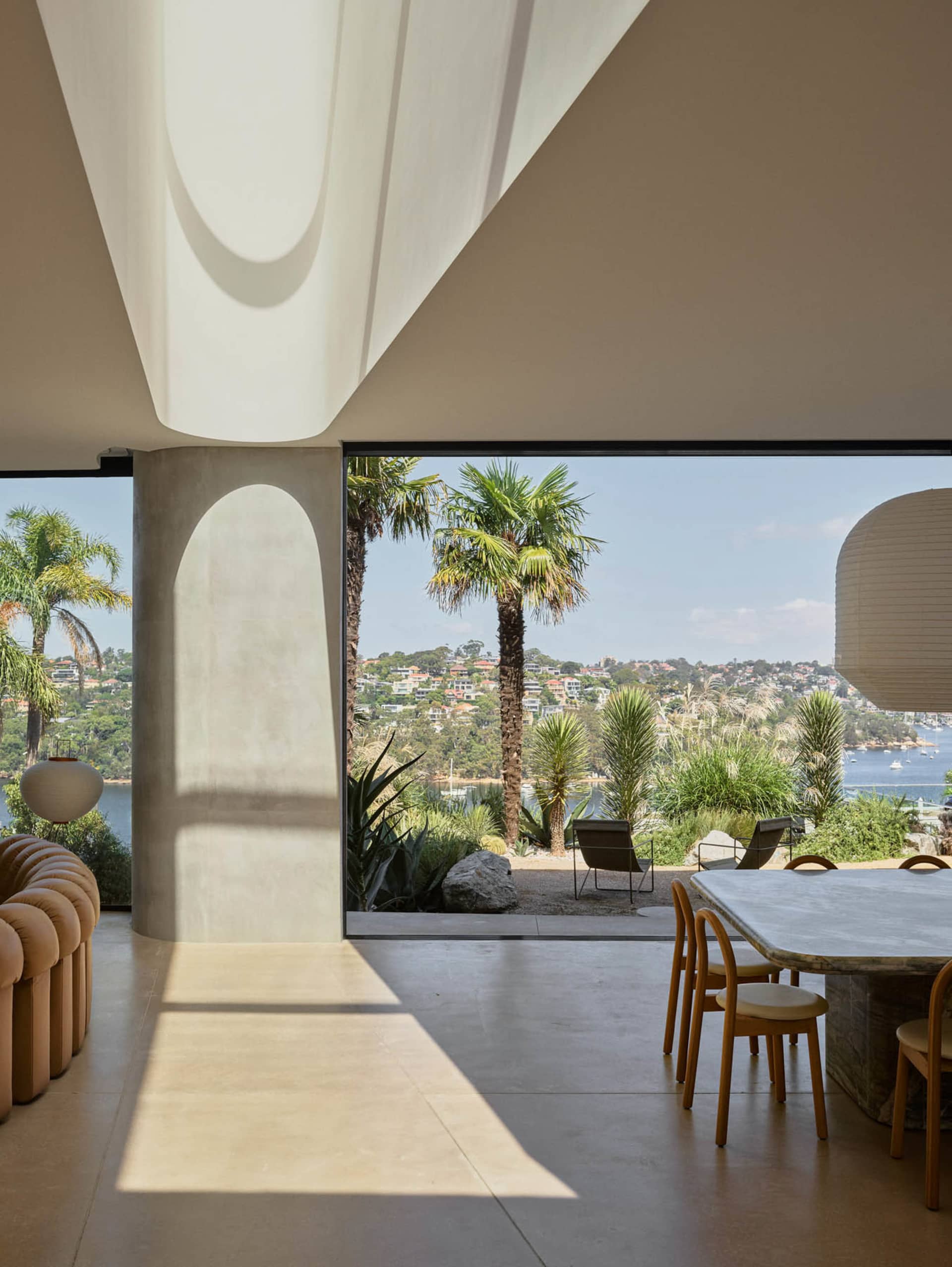 Modern residential interior featuring concrete flooring and wooden furniture.