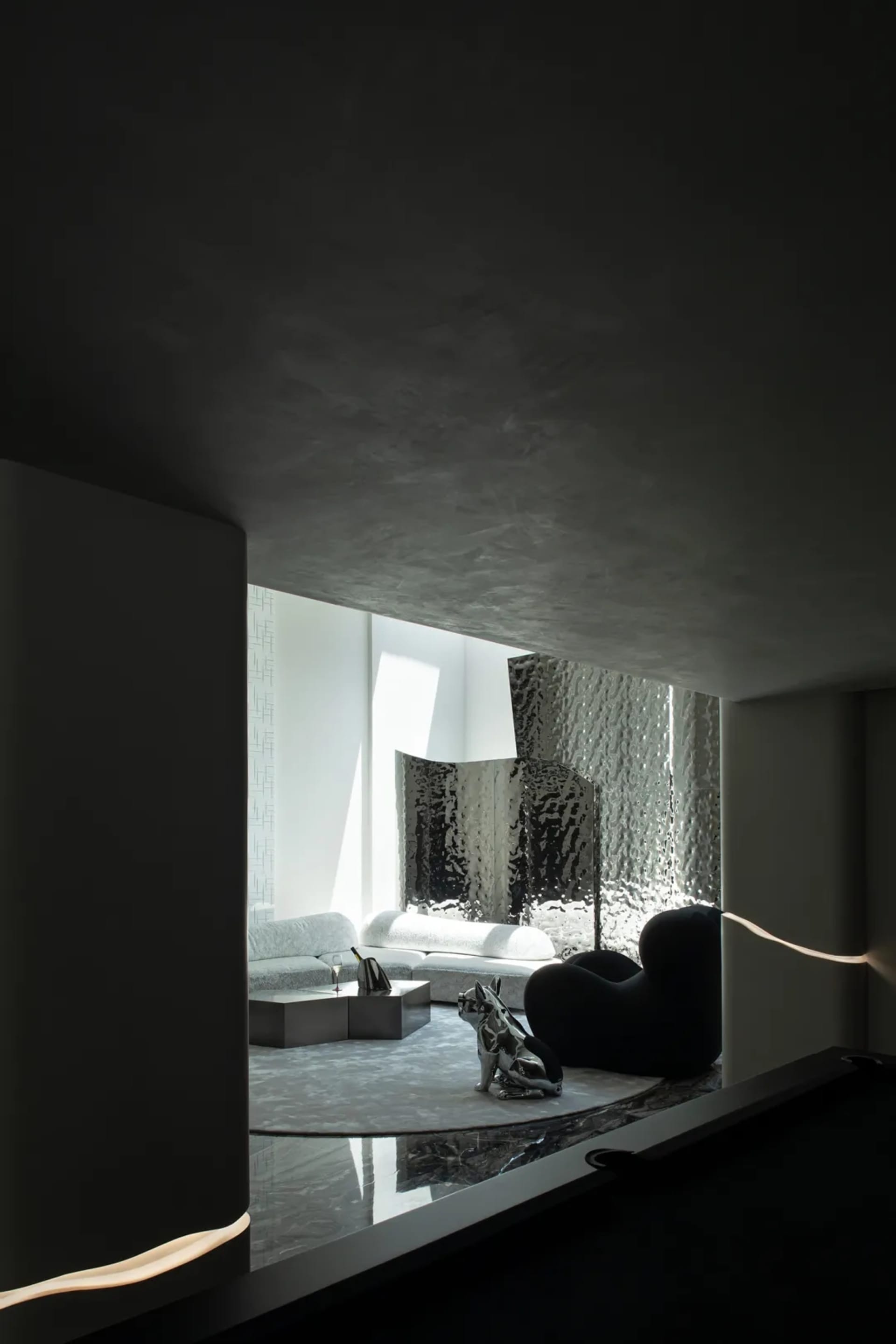 A minimalist living room with metallic-textured couches and black furniture. Modern and sleek design elements.