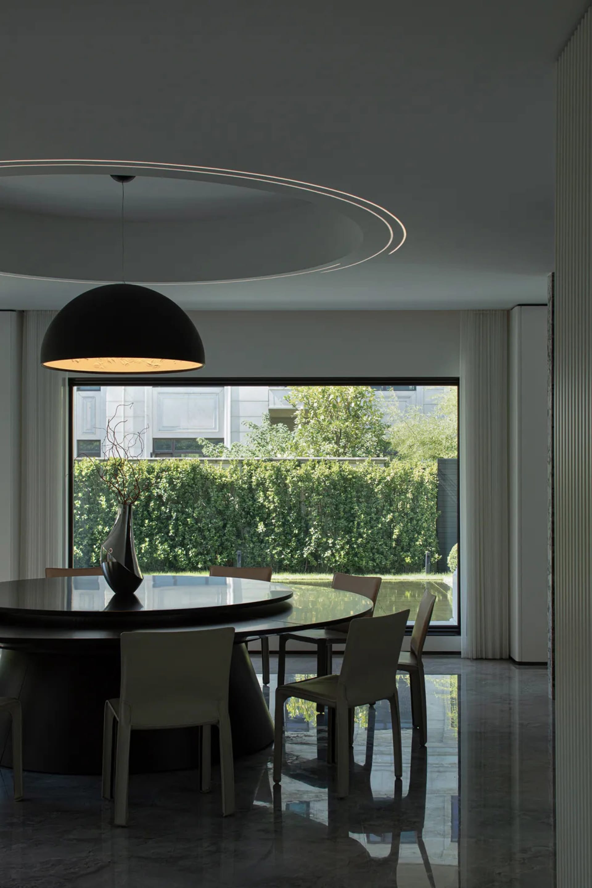 Modern dining room featuring a glass table and moon lighting.
