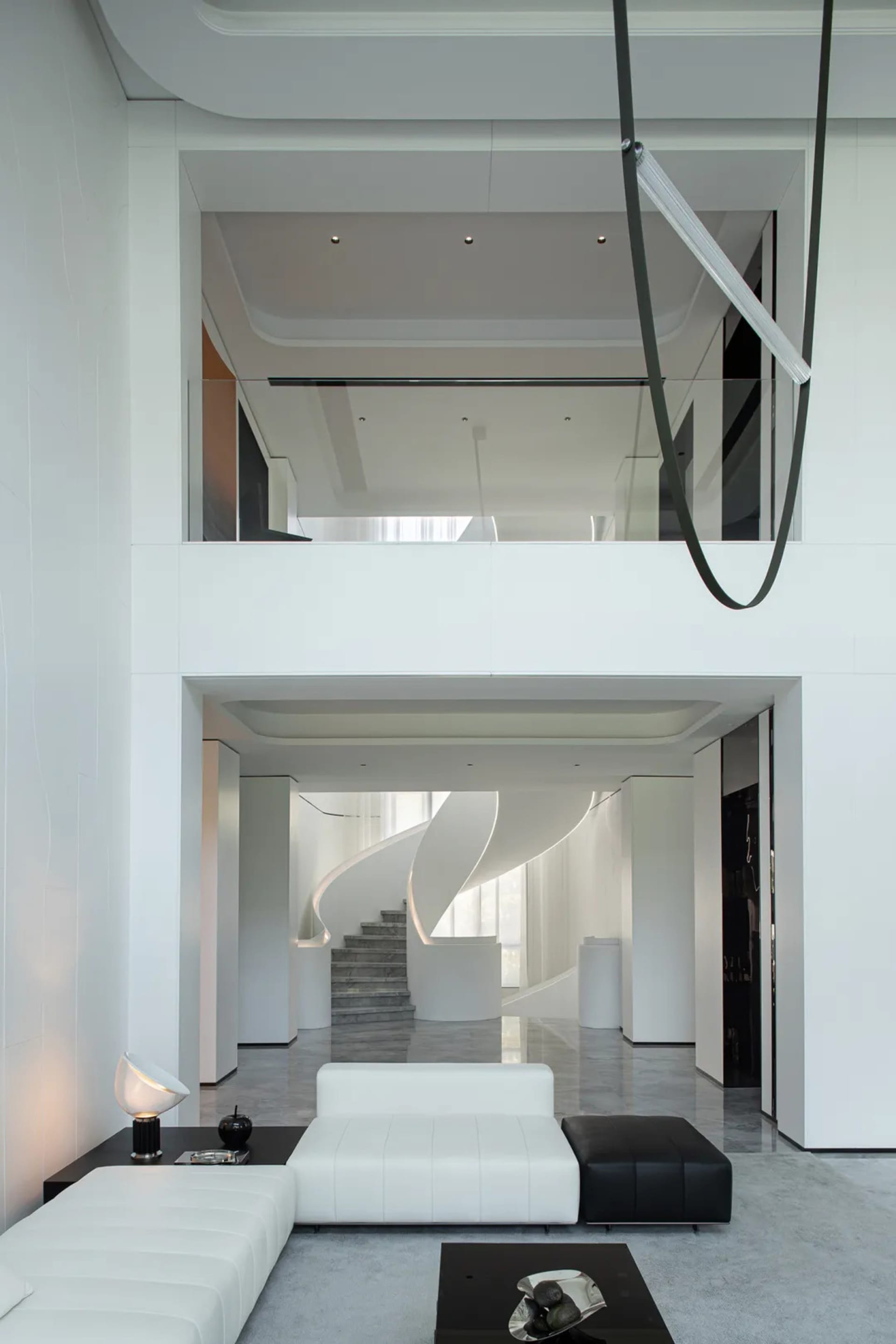 A modern, white and concrete residential living room with minimalist furniture and sleek lighting.
