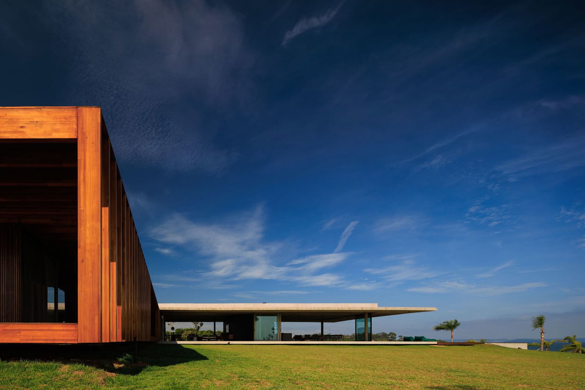 A modern villa with wood and glass exterior features large windows and a minimalist design.
