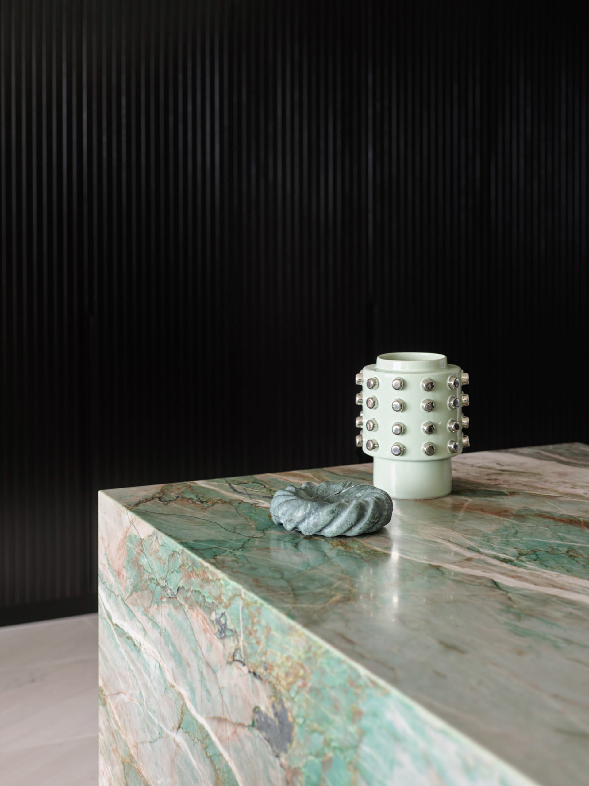 A modern-style, marble accessory with ceramic accents on a polished marble surface.