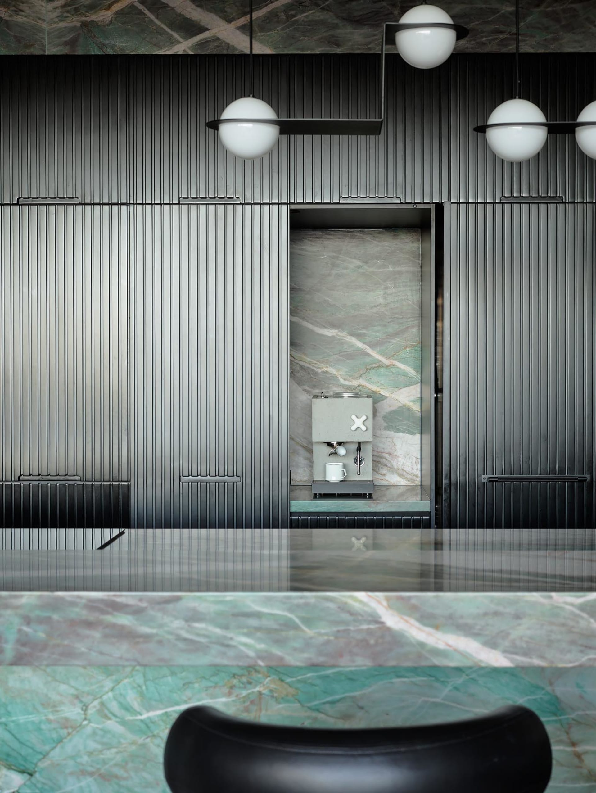 A minimalist coffee shop interior featuring a marble counter and modern design elements.