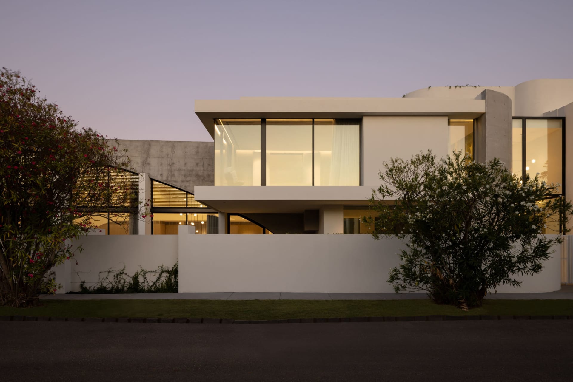 A modern residential home featuring a combination of concrete and glass materials on its exterior.