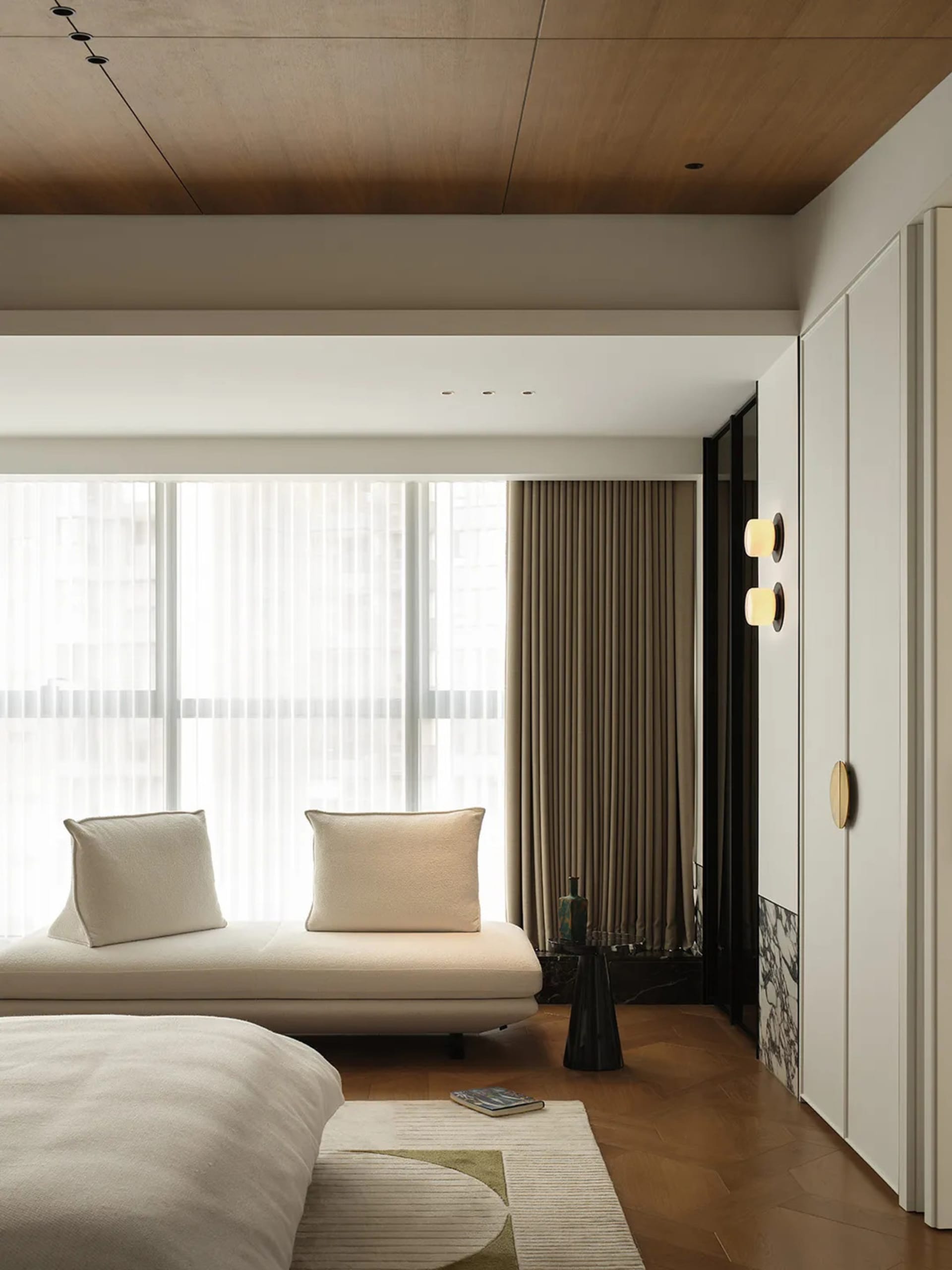 Bedroom featuring minimalist decor with wooden ceiling, light-colored bedding, and beige curtains.