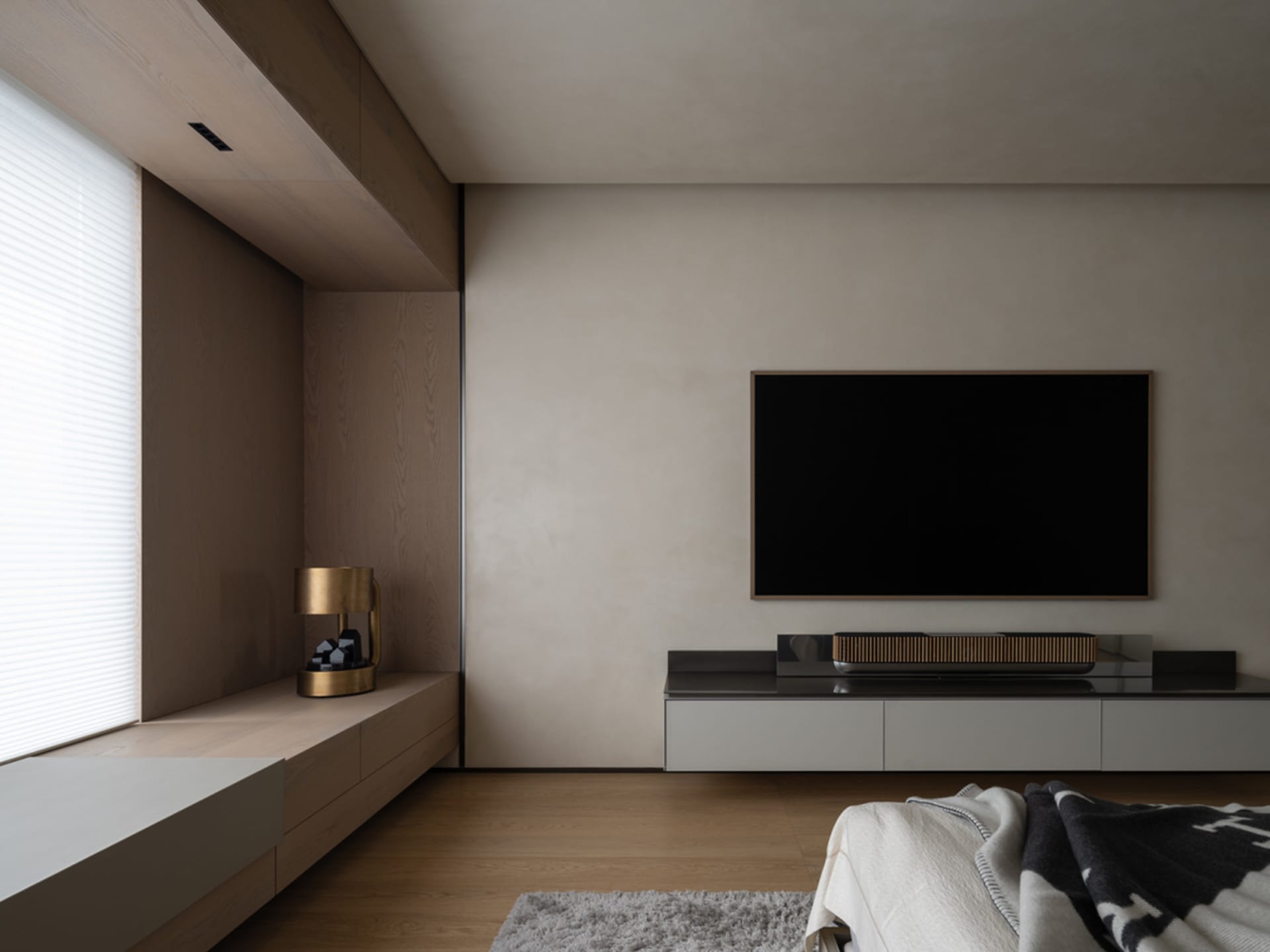 Modern minimalist living room with wood flooring, leather furniture, and metal accents.