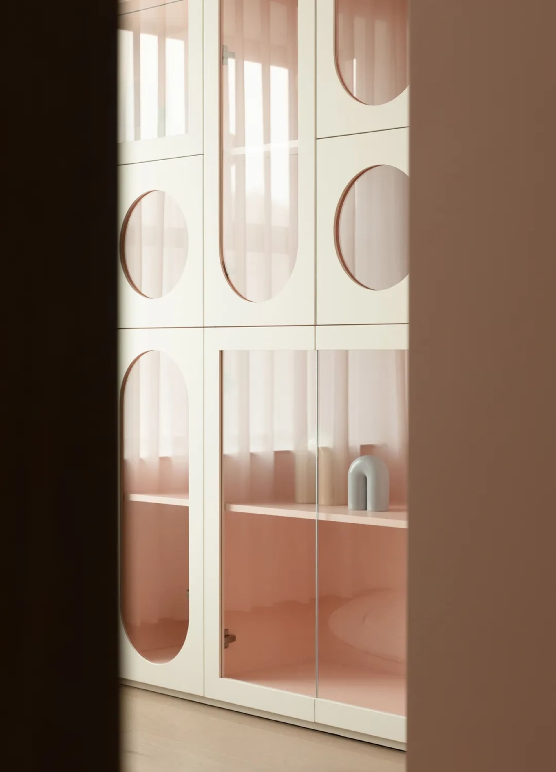 Modern storage cabinet featuring glass doors and shelves.