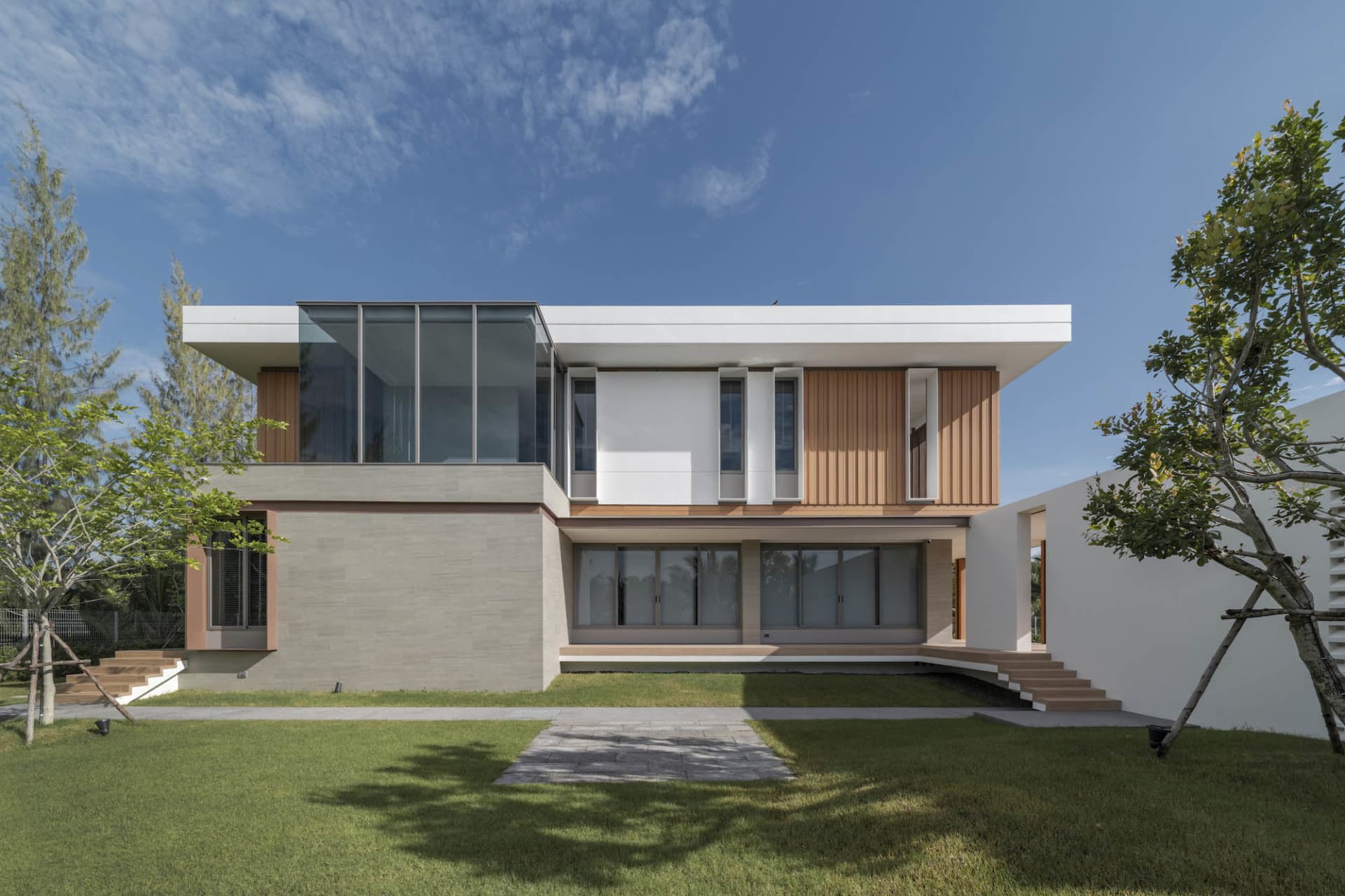 A modern residential building featuring glass, timber, and concrete materials.