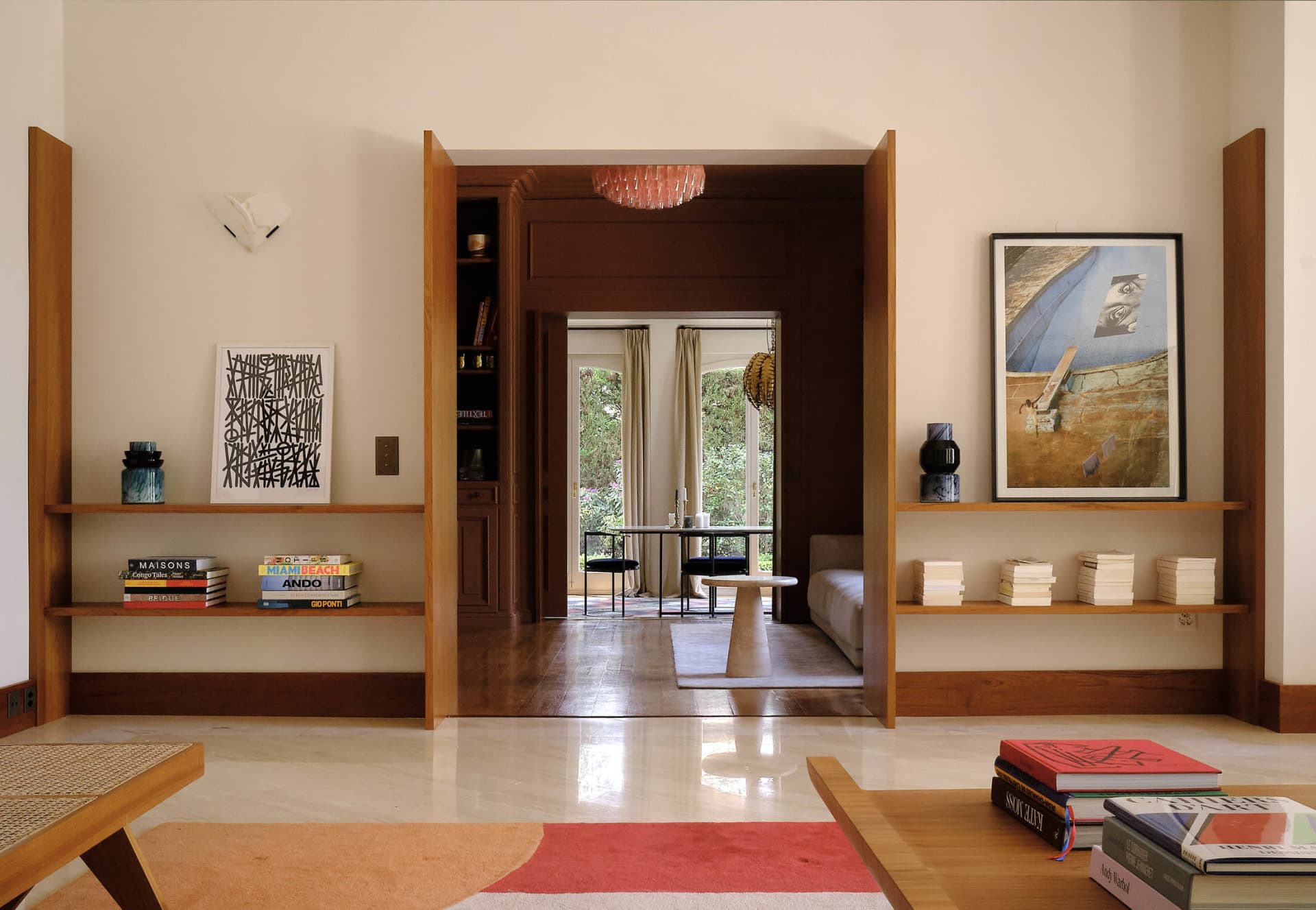 An industrial-style living room with wooden shelves and a view of a dining area.