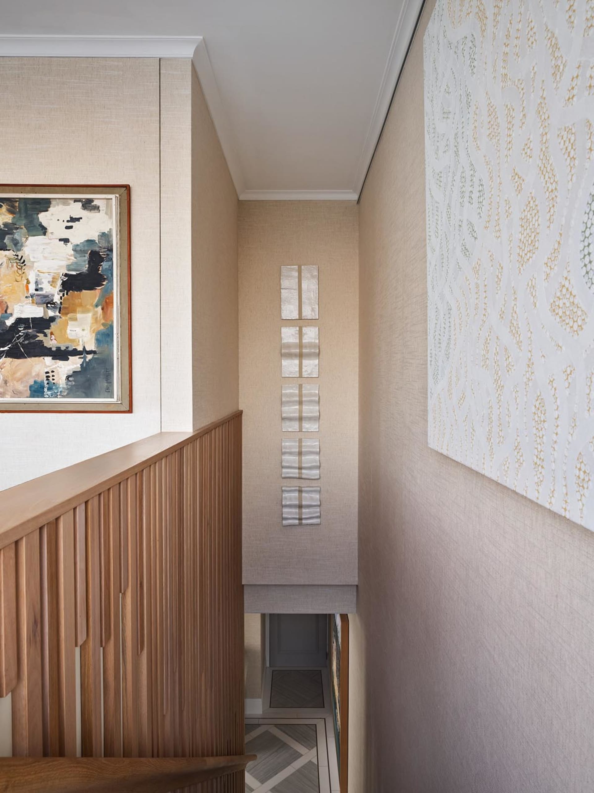 Modern interior design featuring contemporary stairs with textured wood paneling and neutral-colored fabric walls.