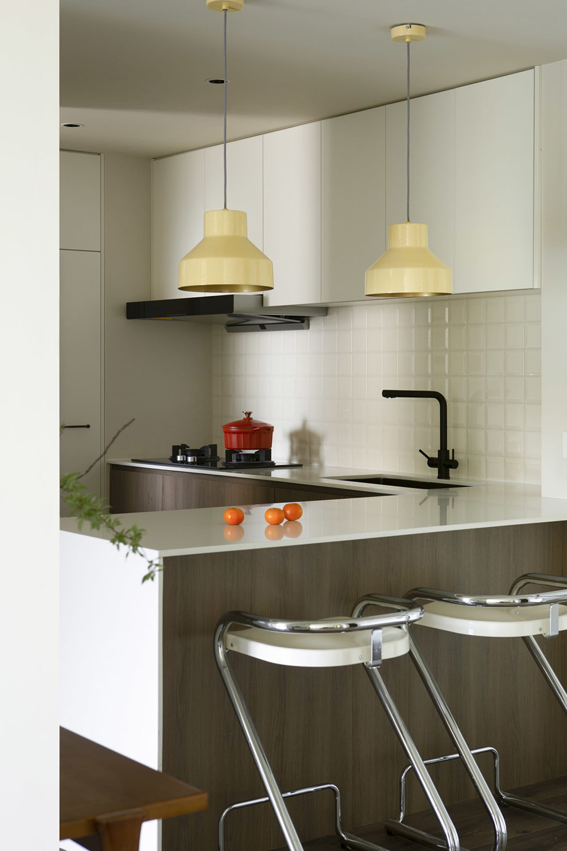 A spacious, modern kitchen with white-painted walls and ceiling, wooden flooring, and glass elements.