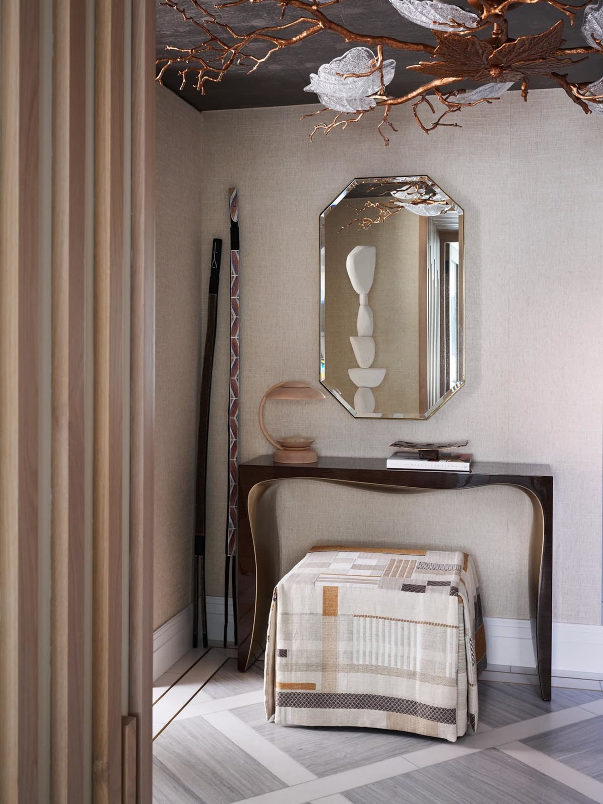 Modern entrance hall featuring mixed materials and elegant furnishings.
