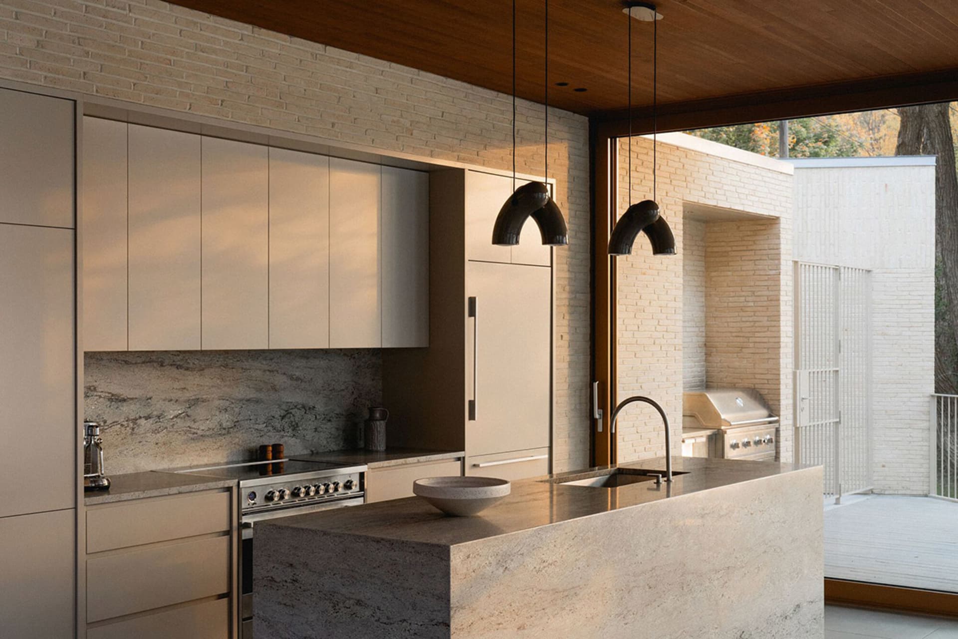 Modern kitchen featuring marble countertops and brick walls