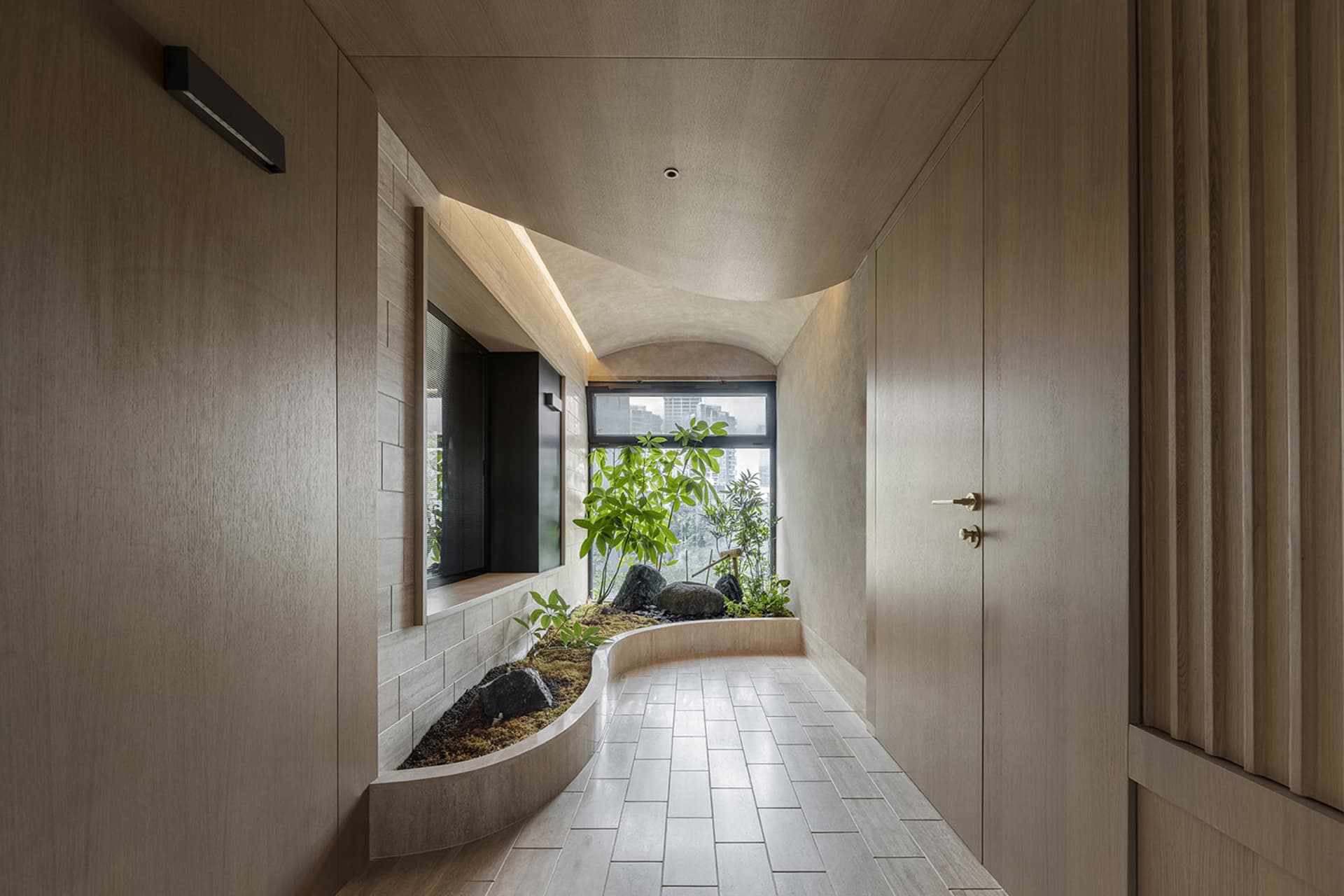 Minimalist interior space with wooden walls and a small indoor garden.