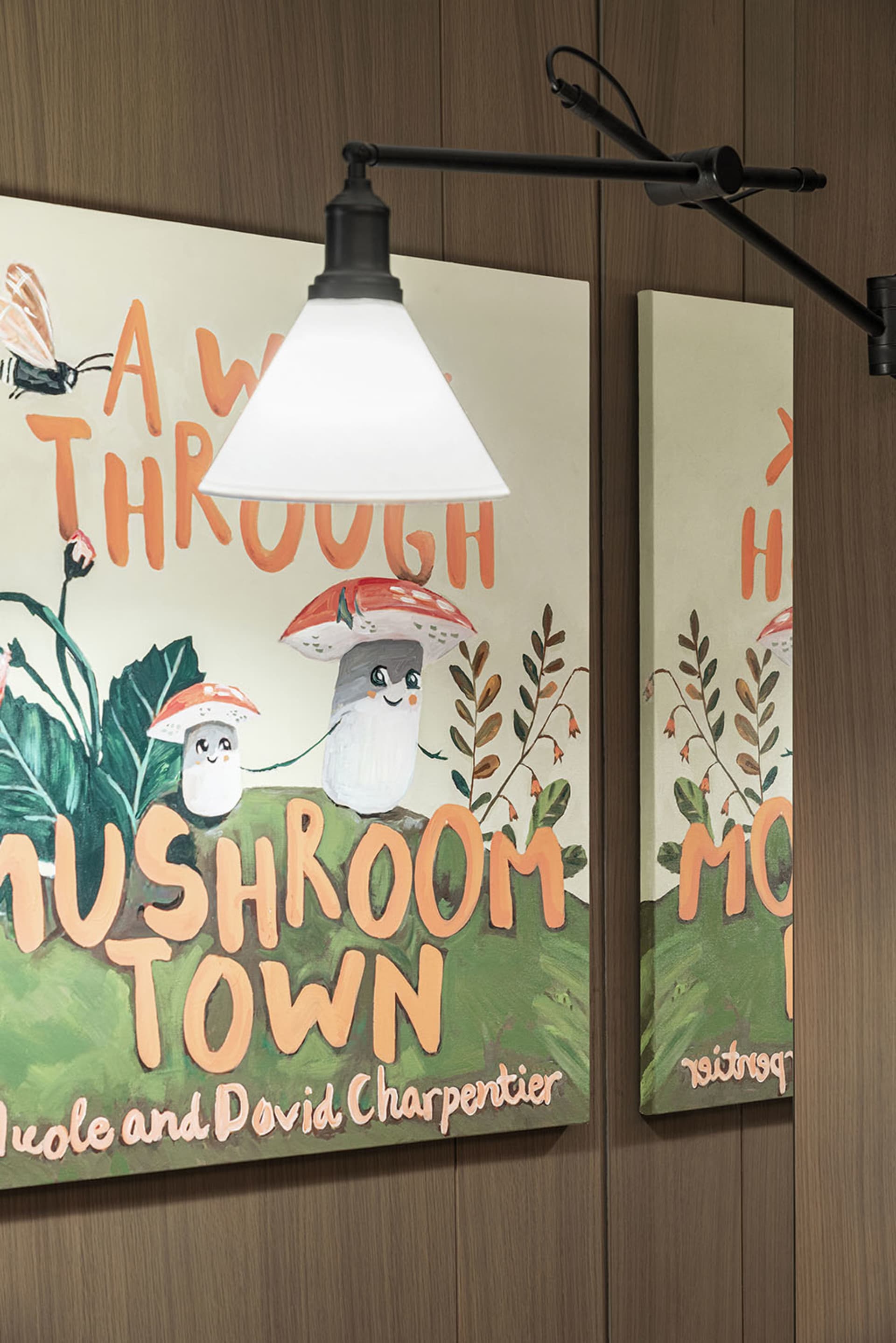 A mural featuring cheerful mushroom characters on a green hill in a children's room setting.