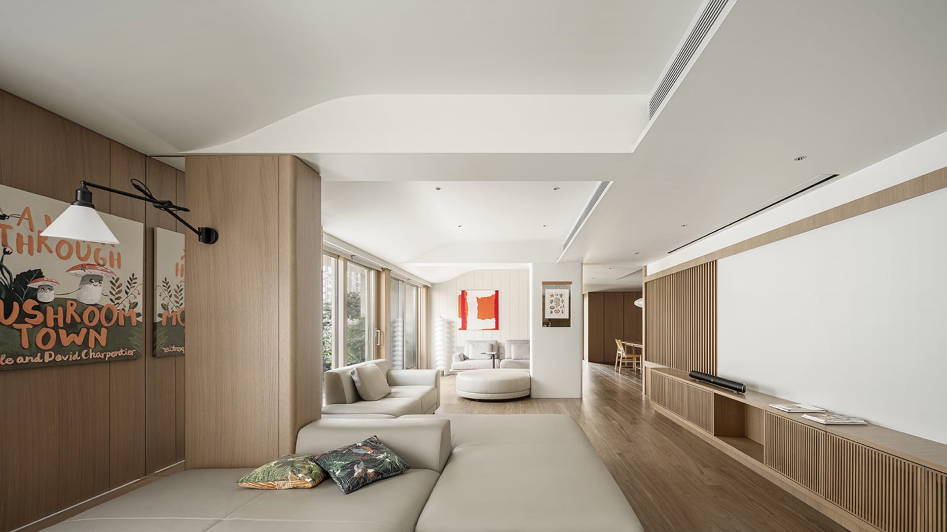 Modern living room interior featuring a beige sofa with cushions, a white ottoman, and a wooden floor with integrated ceiling