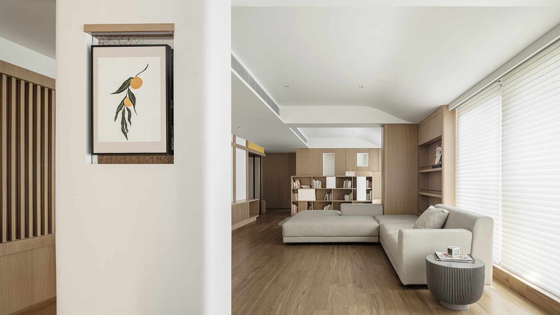 Modern minimalist living room featuring white accents and light-colored materials.
