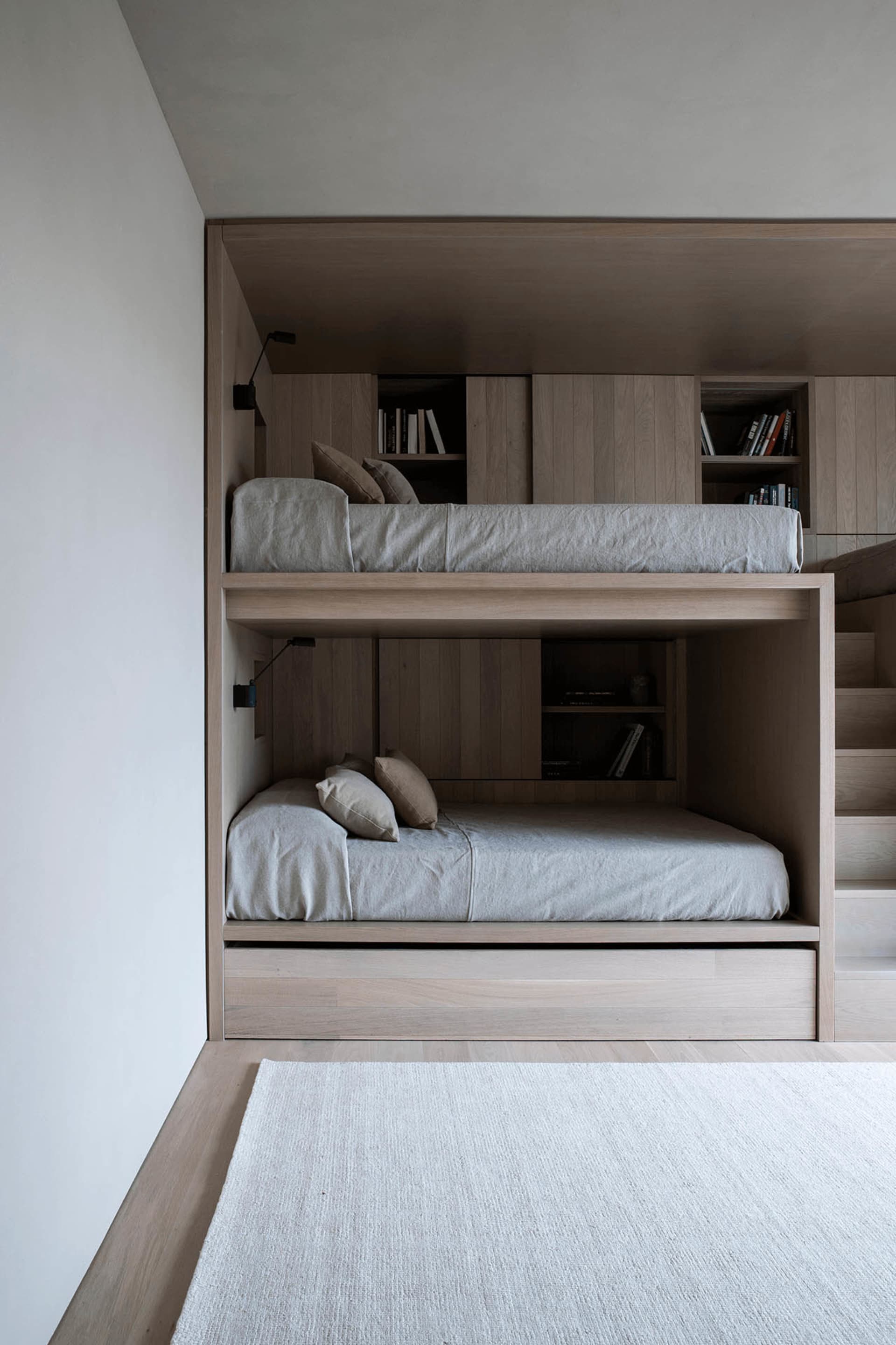 Modern minimalist bunk beds with grey bedding.