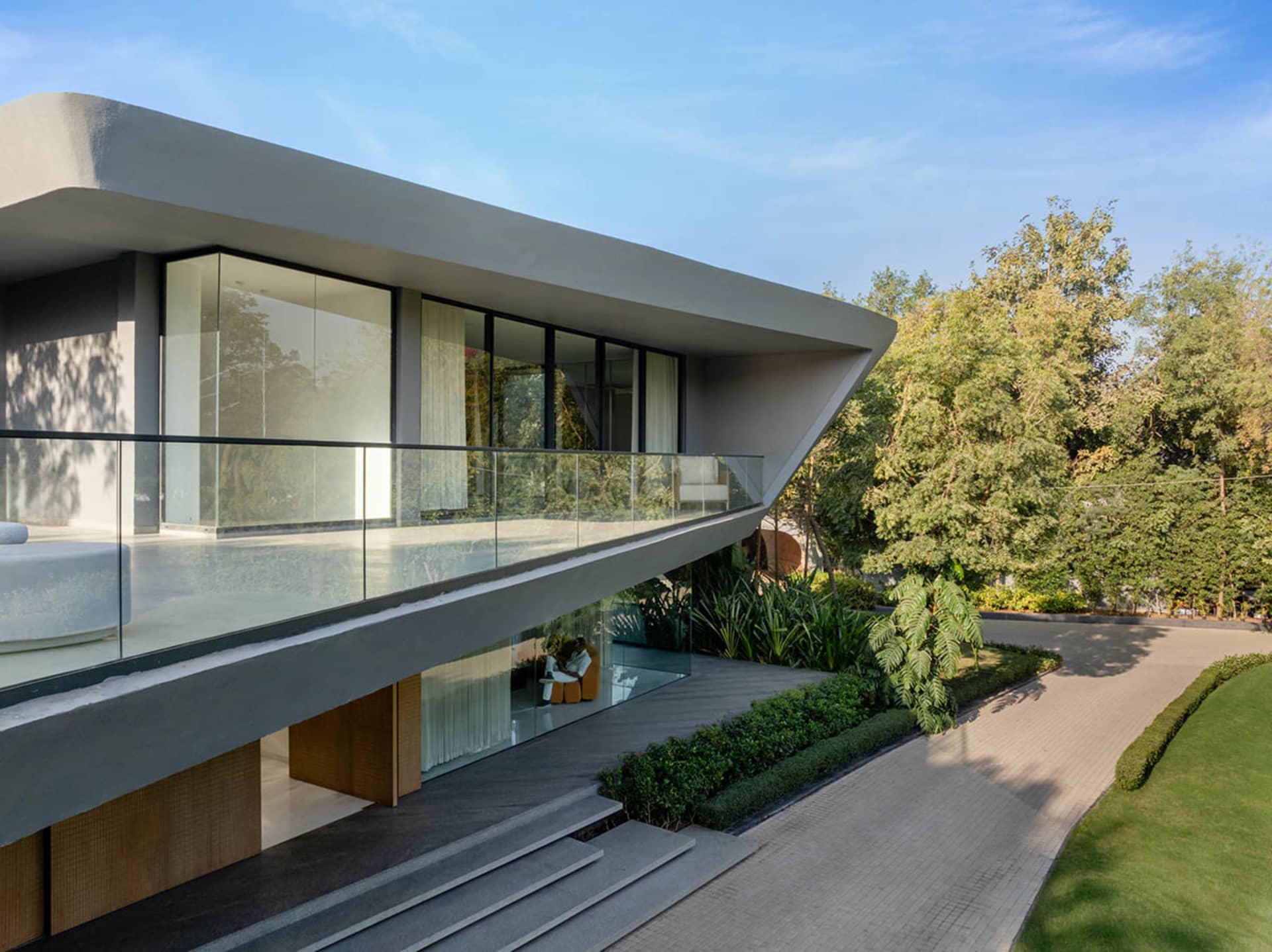 Modern residential home with concrete exterior and large glass windows and doors.